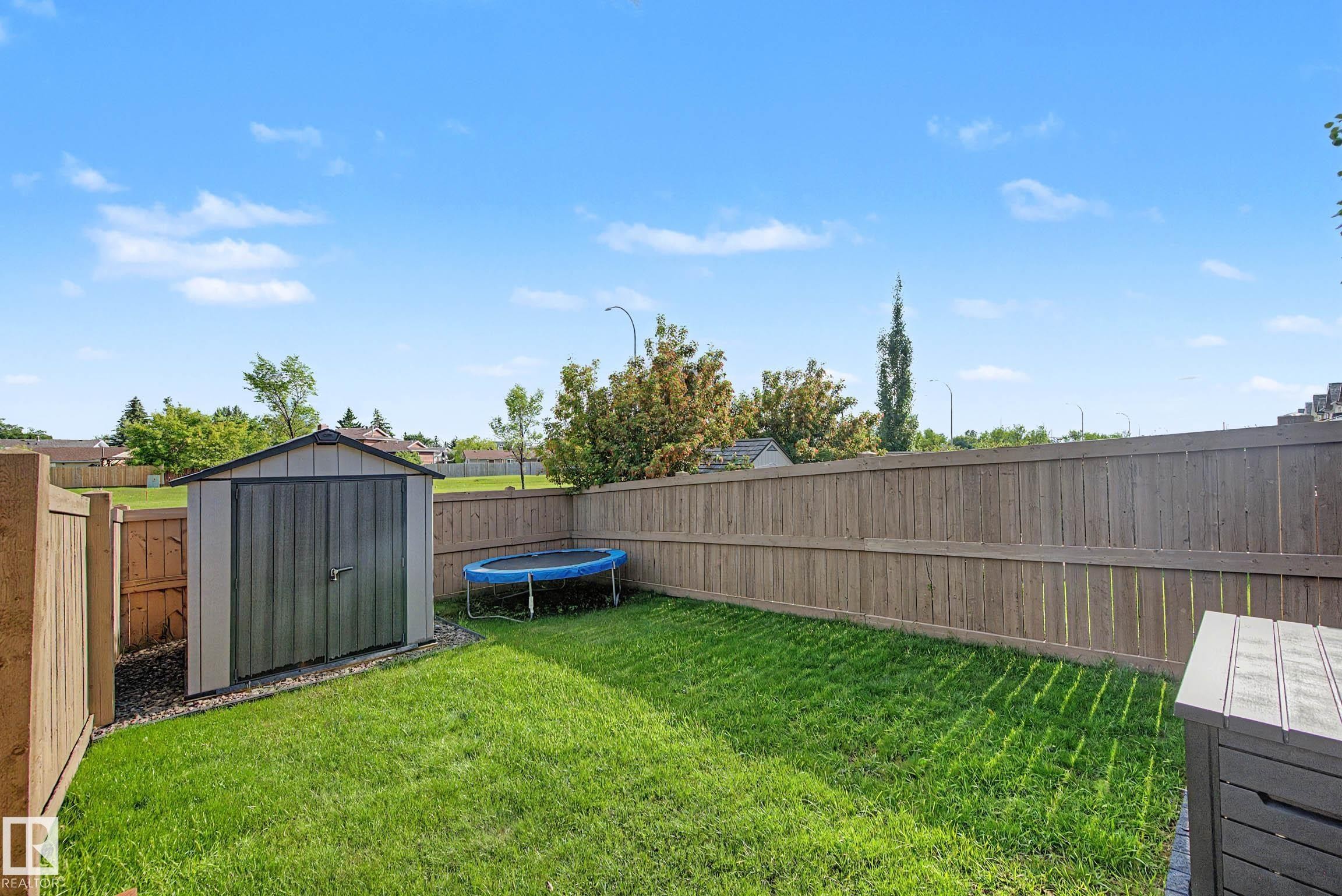 Spacious backyard featuring a manicured lawn, a garden shed, and a privacy fence - 12119 167A Avenue, Edmonton, AB