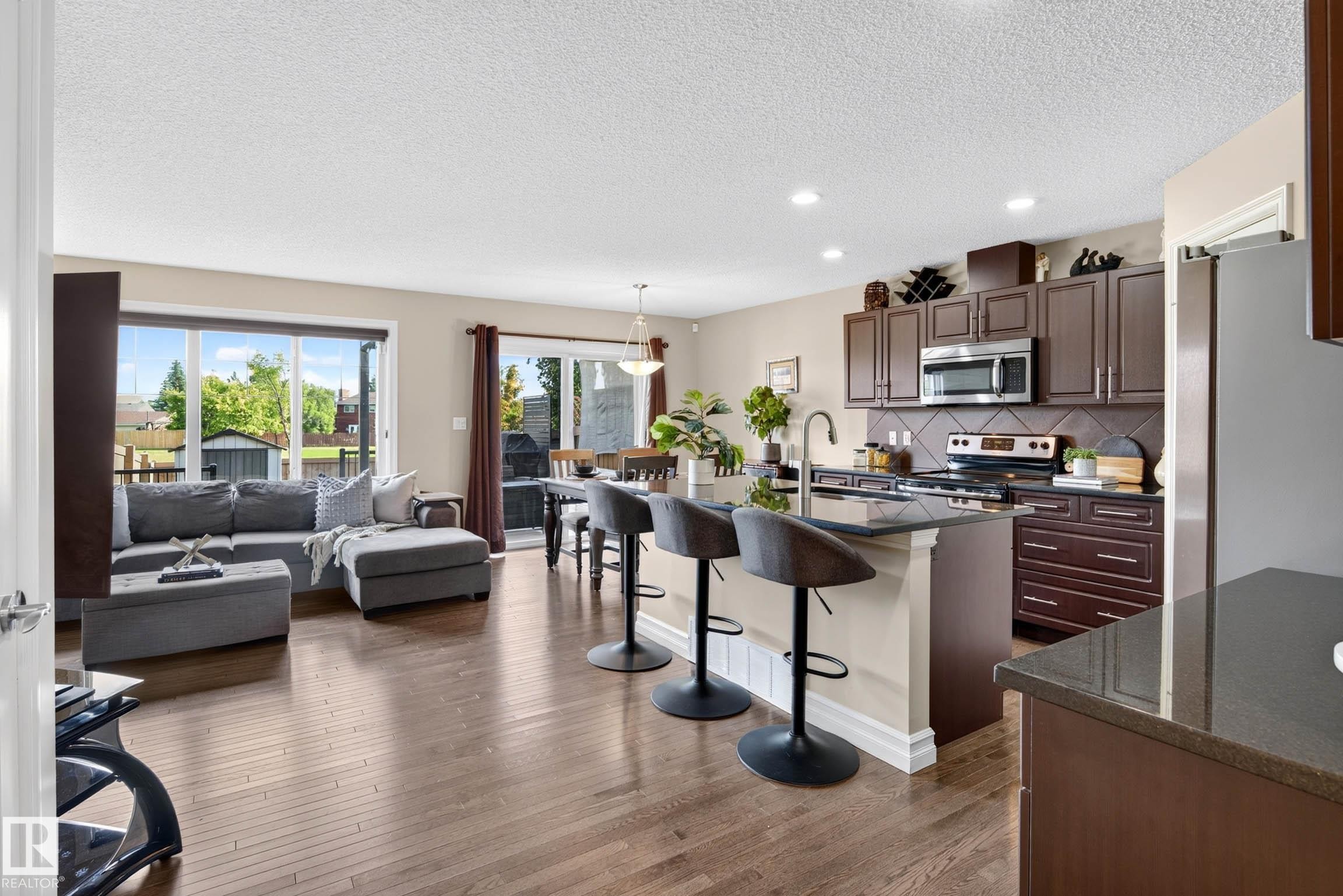Open-concept living area featuring rich wood-finish flooring throughout - 12119 167A Avenue, Edmonton, AB