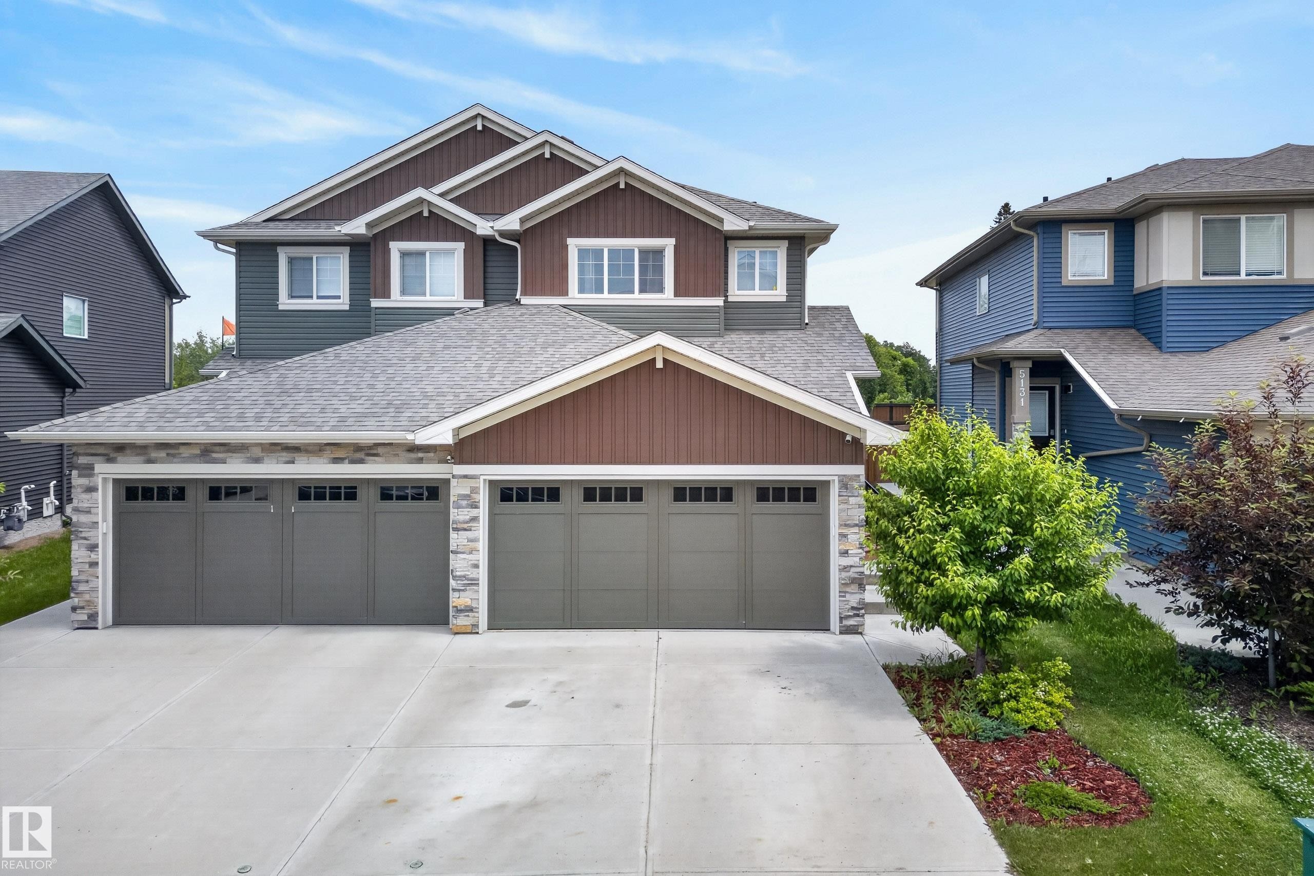 Contemporary two-story residence featuring a combination of horizontal siding, vertical siding, and stone accents - 5129 Lark Crescent Nw, Edmonton, AB - Outdoor With Facade