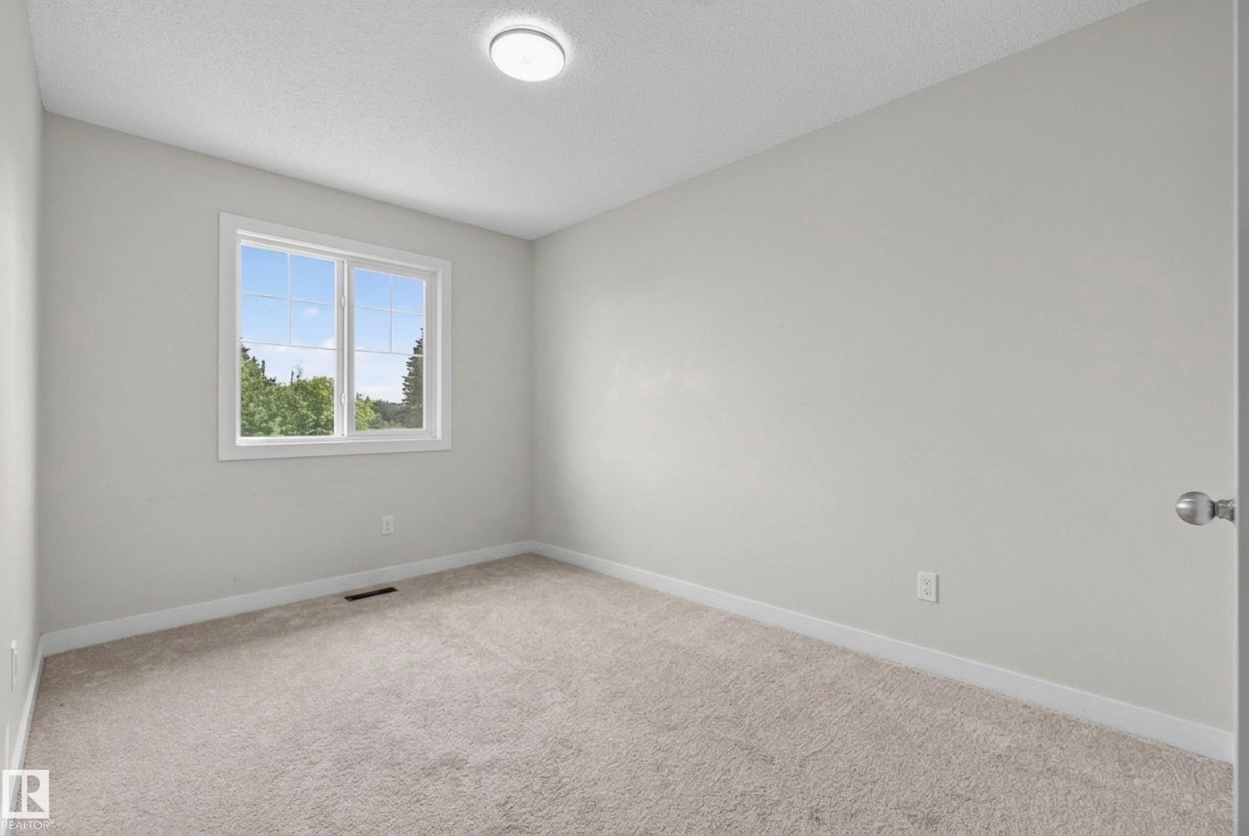 Neutral painted walls and light-toned carpeting create a versatile interior - 5129 Lark Crescent Nw, Edmonton, AB - Indoor Photo Showing Other Room