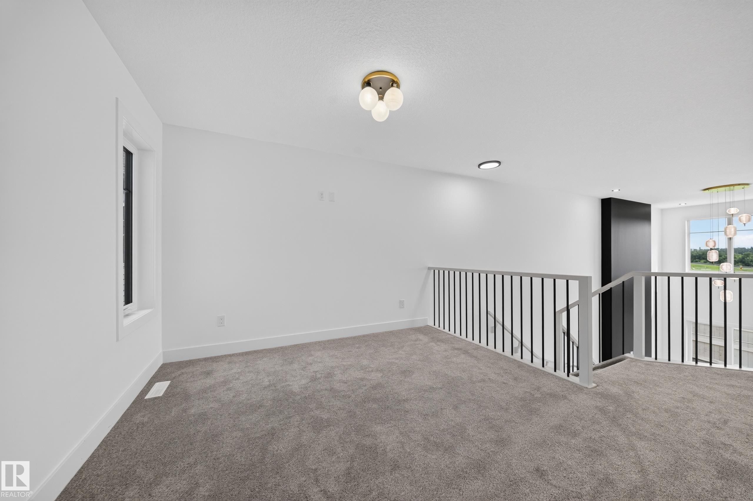 Open-concept loft area with a contemporary chandelier and modern flush-mount lighting - 803 30 Avenue, Edmonton, AB