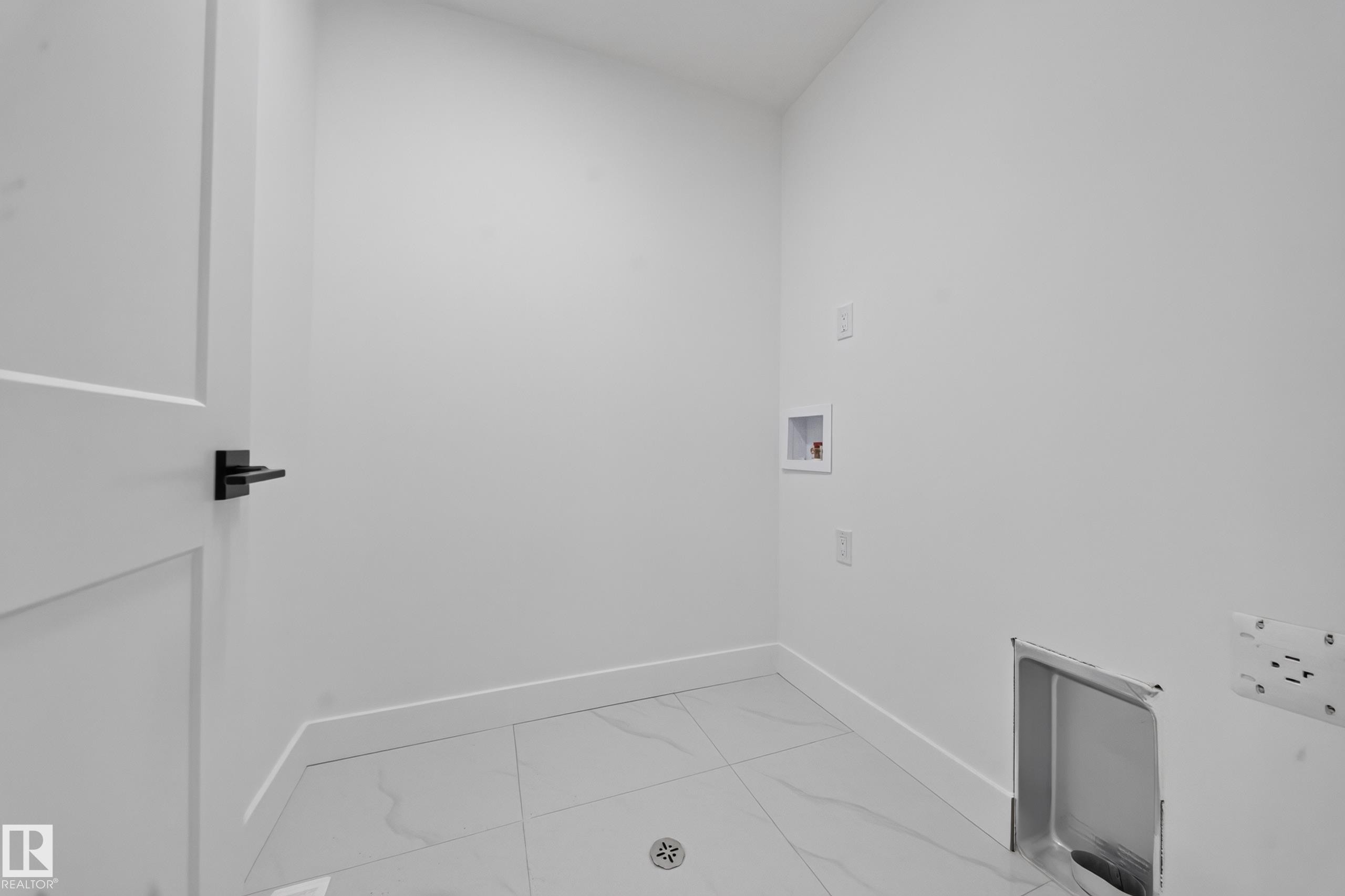 Upper-level landing featuring plush gray carpeting, white walls, and a contemporary black metal baluster railing with a light-toned wooden handrail - 803 30 Avenue, Edmonton, AB