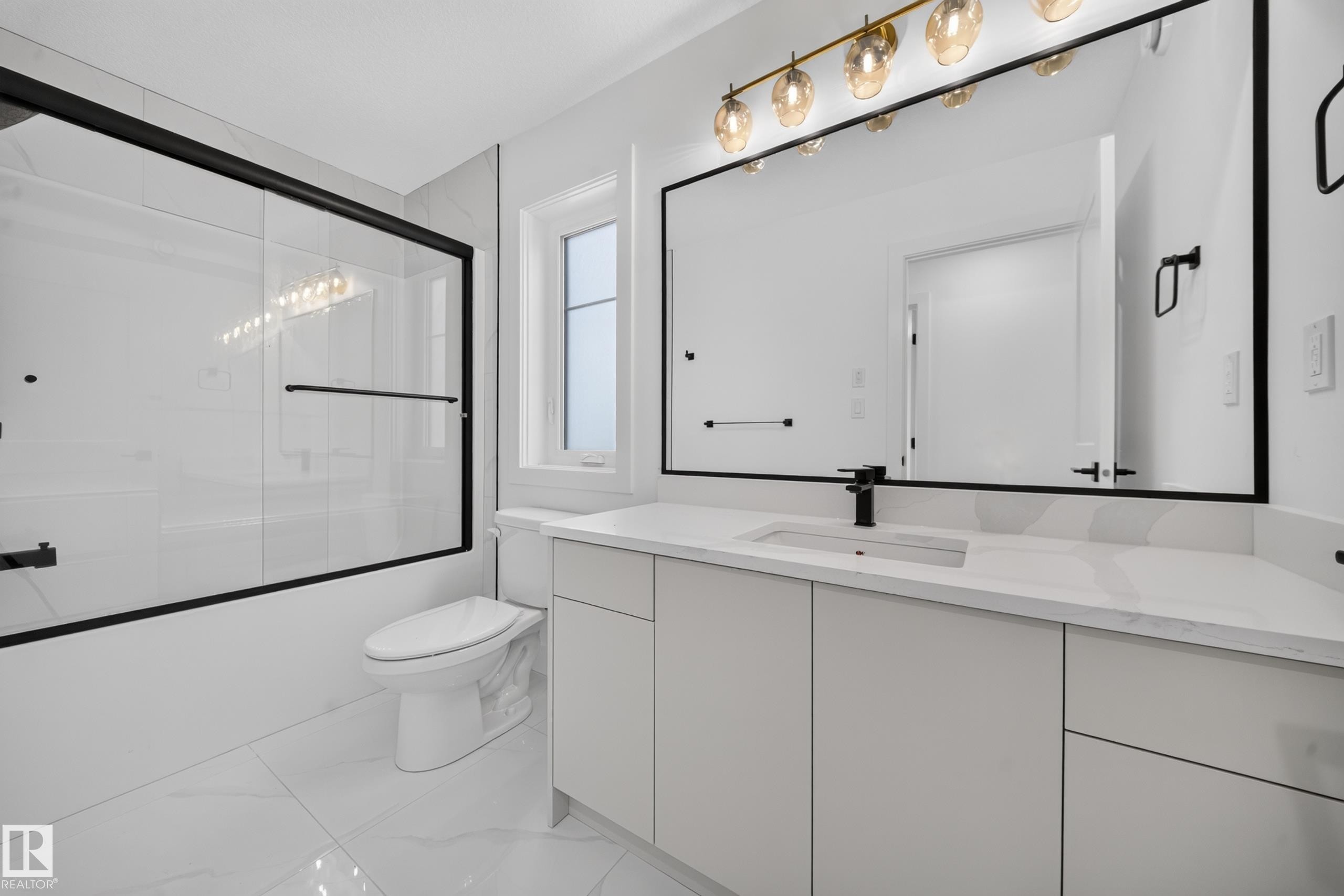 Dedicated laundry space featuring white wall finishes, white baseboards, and a white paneled door with a black lever handle - 803 30 Avenue, Edmonton, AB