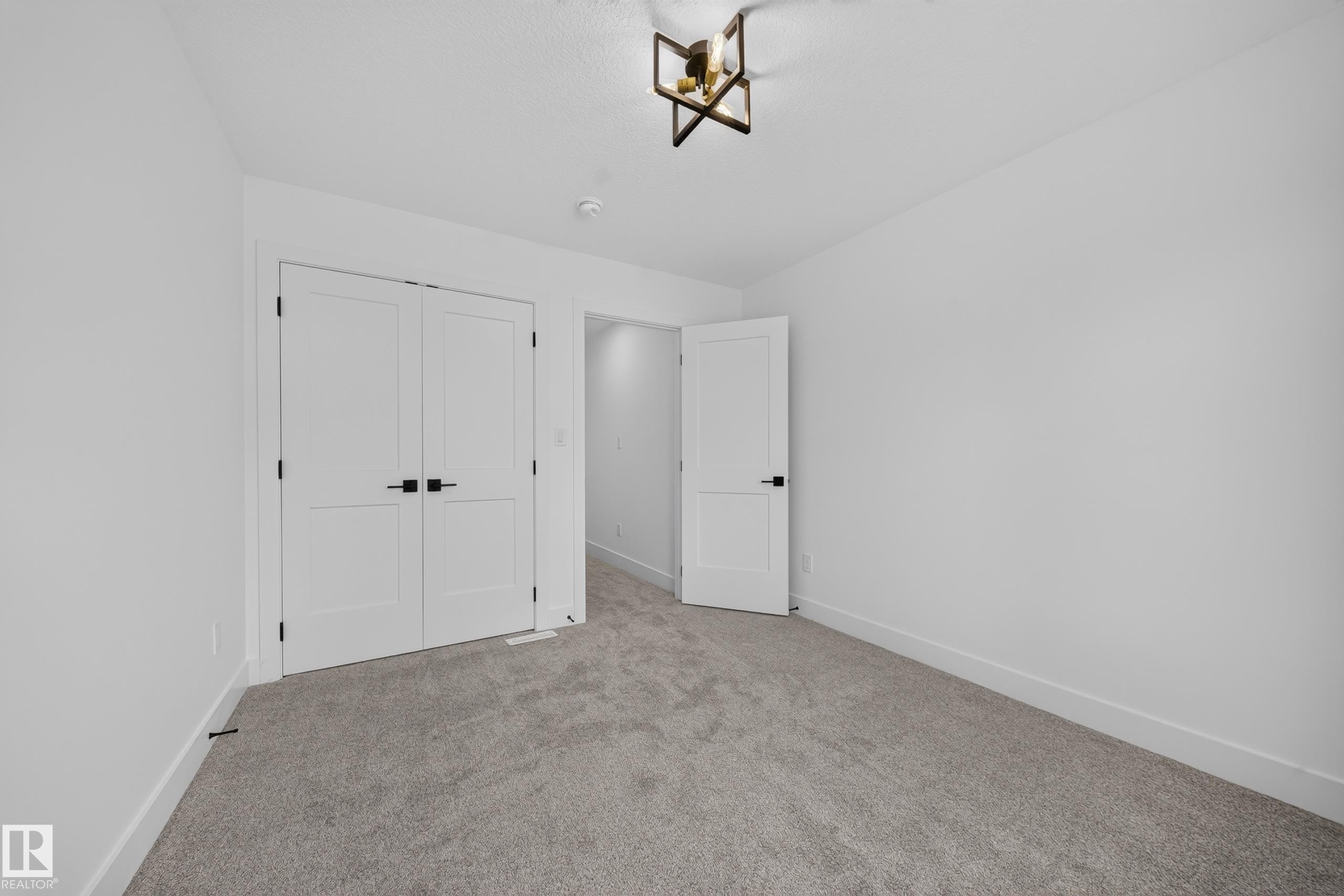 White walls, light gray carpeting, and a modern ceiling light fixture - 803 30 Avenue, Edmonton, AB