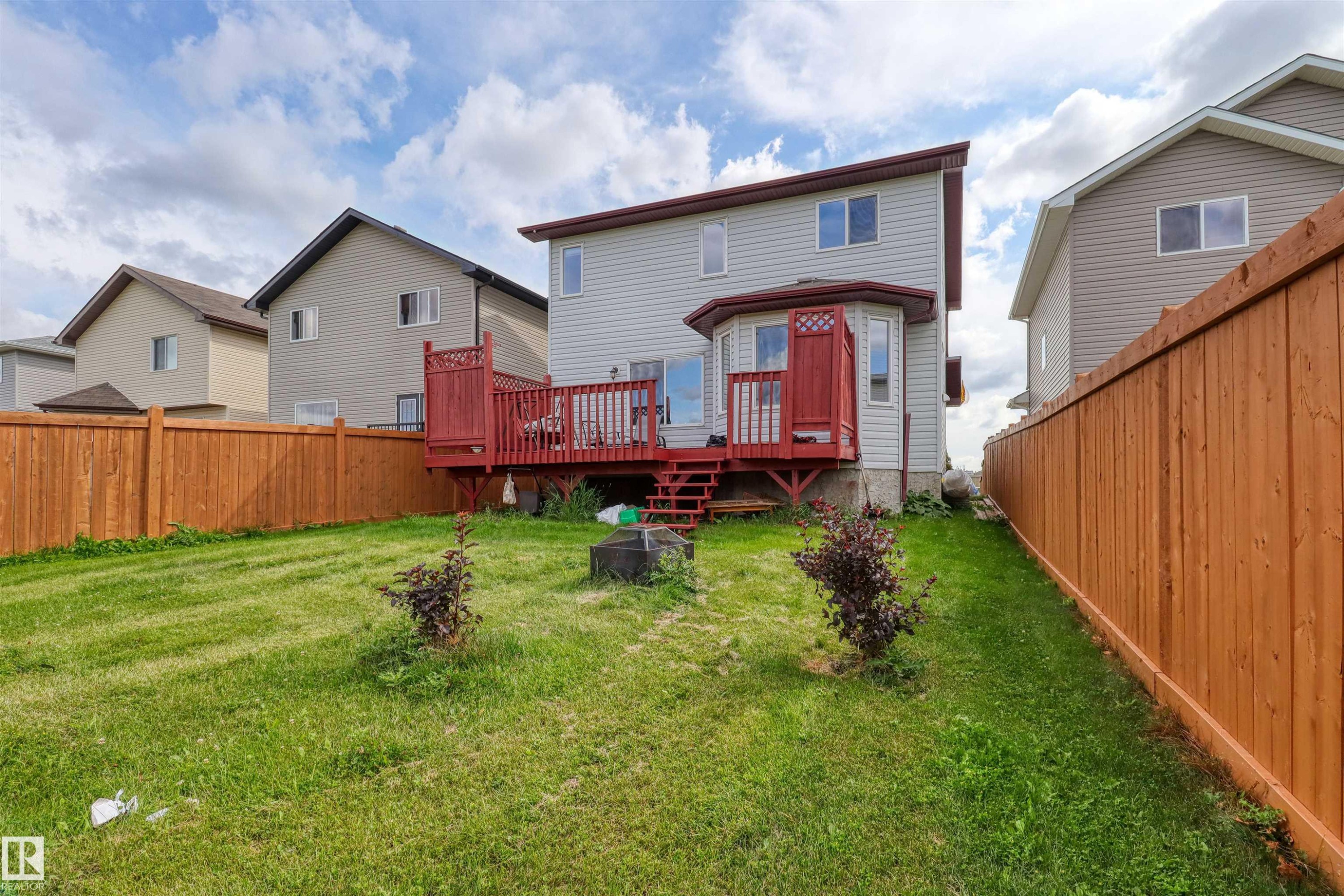 Expansive backyard featuring a manicured lawn, full wood fencing, and a multi-level wood deck with a privacy screen - 1216 37C Avenue Nw, Edmonton, AB - Outdoor With Deck Patio Veranda