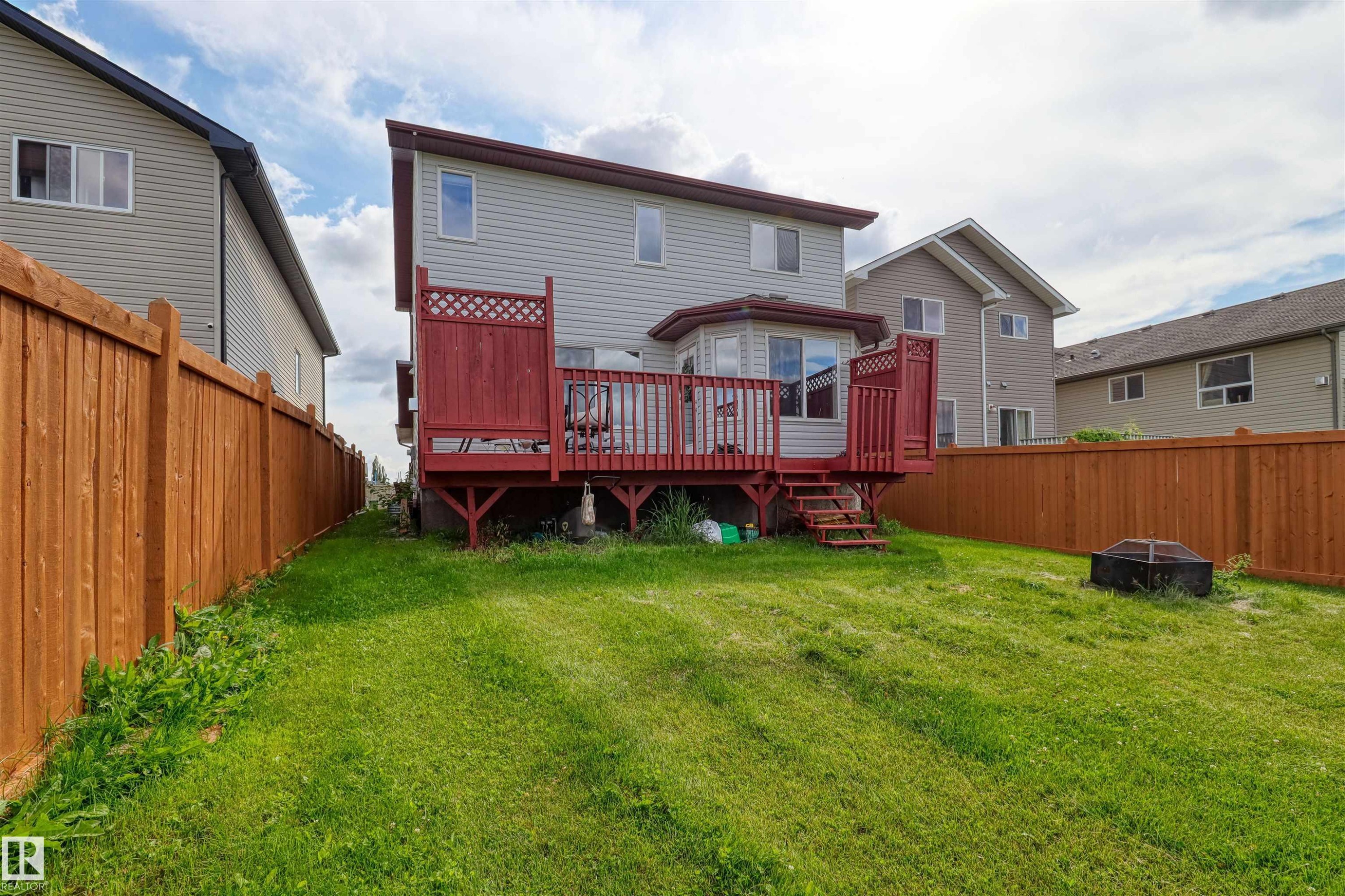 Expansive backyard featuring a large wooden deck with red railings and built-in privacy screens - 1216 37C Avenue Nw, Edmonton, AB - Outdoor With Deck Patio Veranda