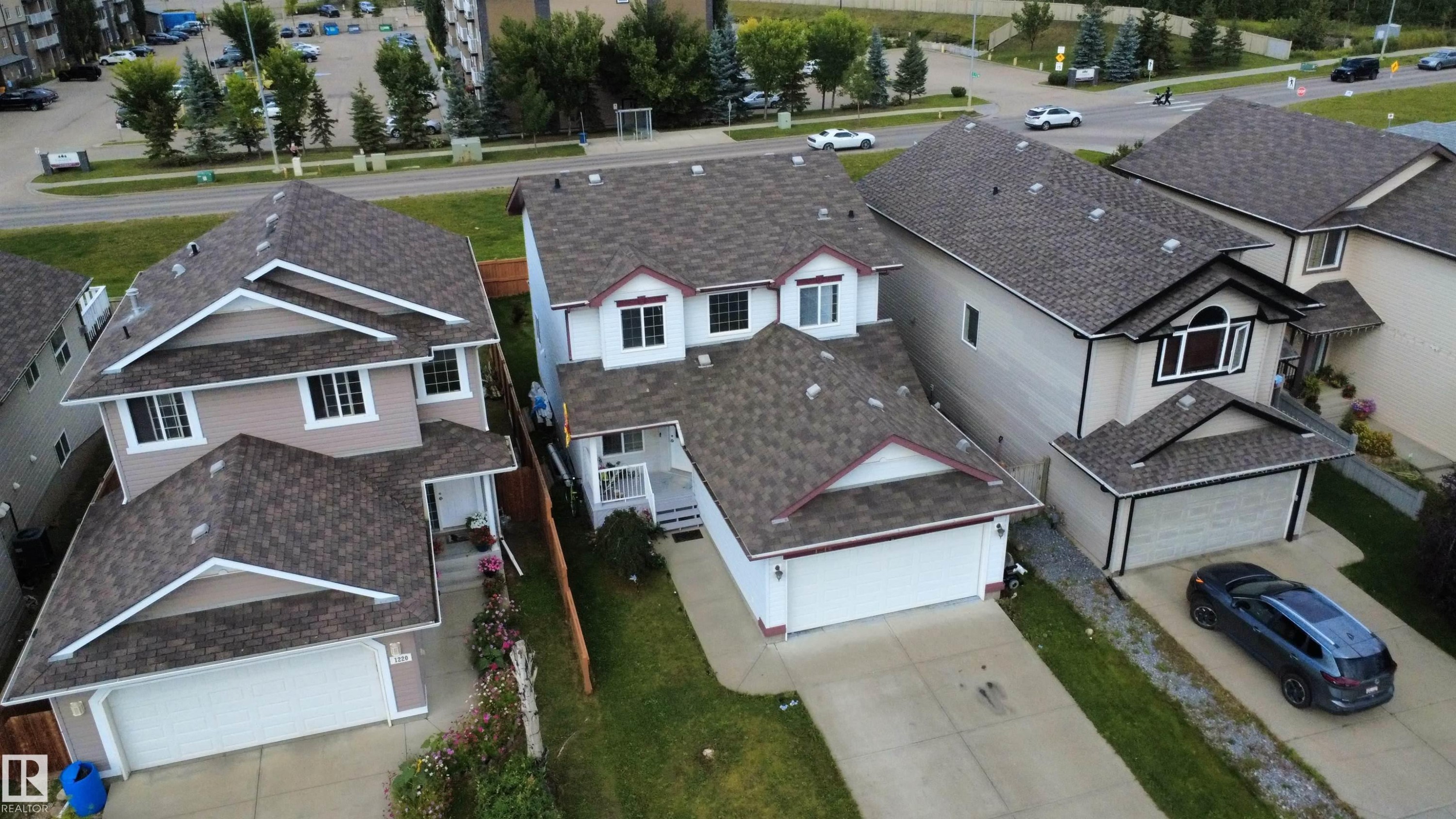 Two-story detached residence featuring a white facade with red trim accents, an attached two-car garage, and a covered front entry - 1216 37C Avenue Nw, Edmonton, AB - Outdoor