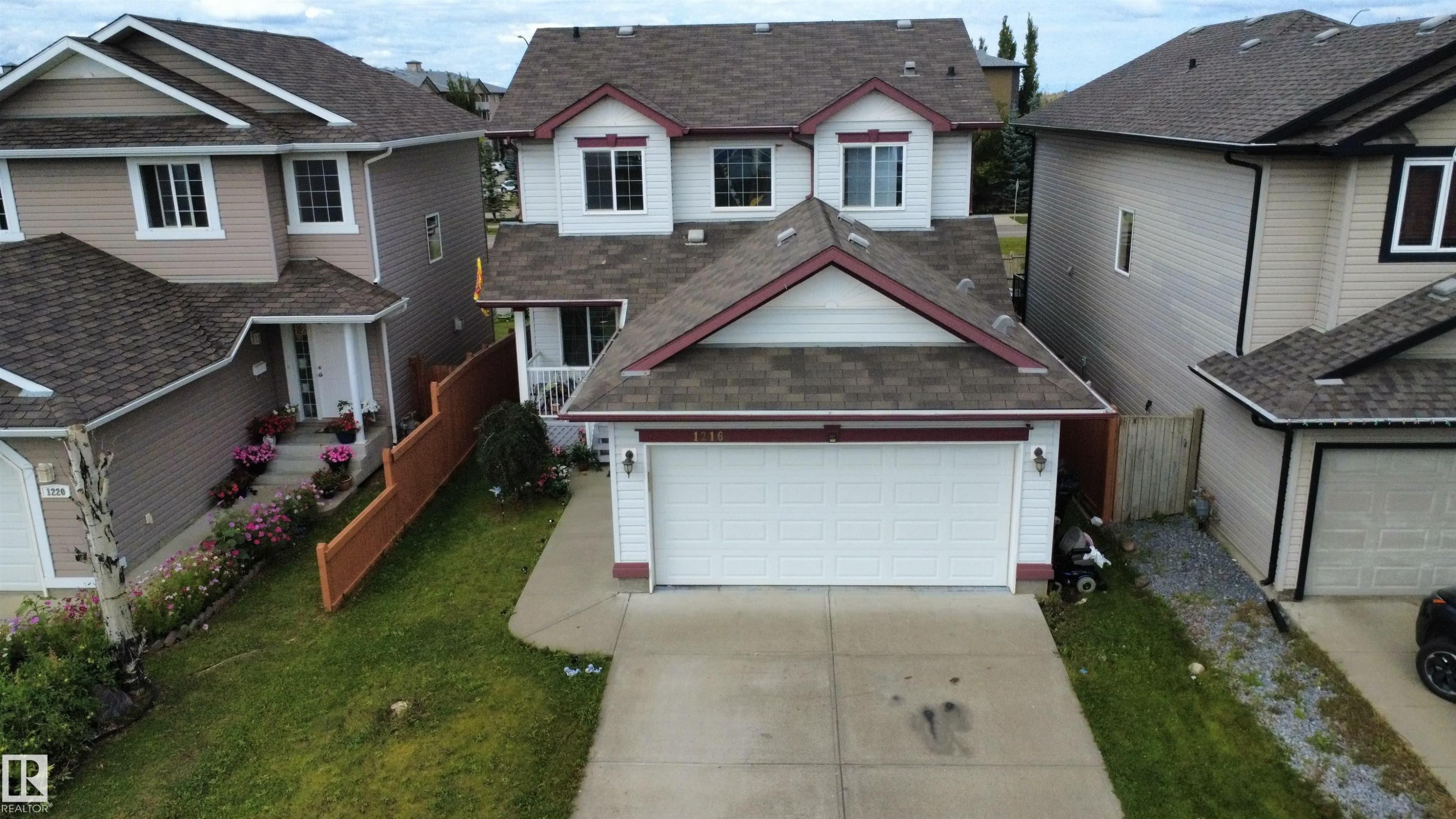 Two-story home featuring a front-facing attached garage and a concrete driveway - 1216 37C Avenue Nw, Edmonton, AB - Outdoor