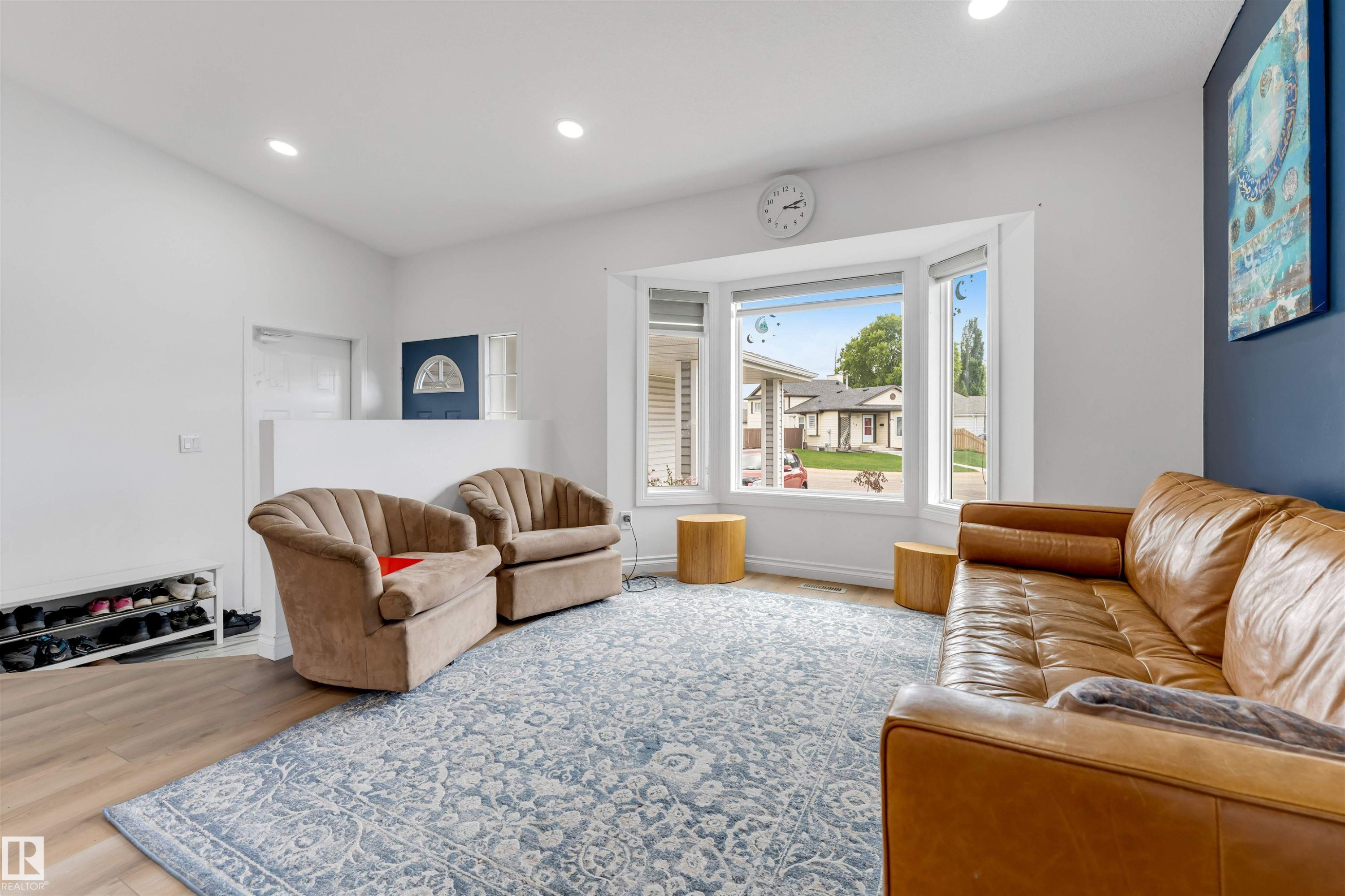 Bright living space featuring a bay window, recessed lighting, wood-finish flooring, and a partial wall separation - 3332 43 Street Nw, Edmonton, AB