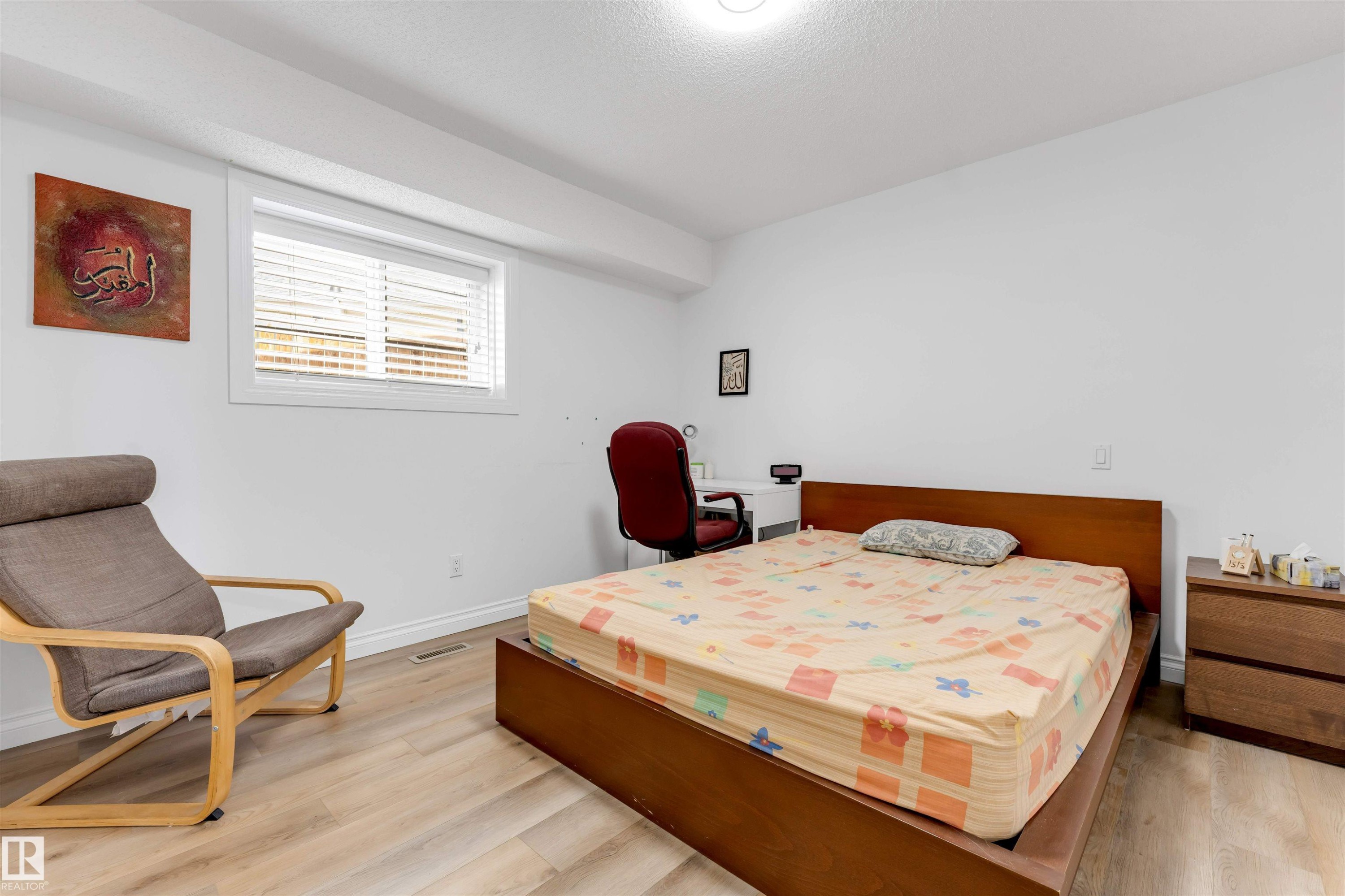 Bedroom featuring light wood-finish flooring, white walls, and a window with horizontal blinds - 3332 43 Street Nw, Edmonton, AB