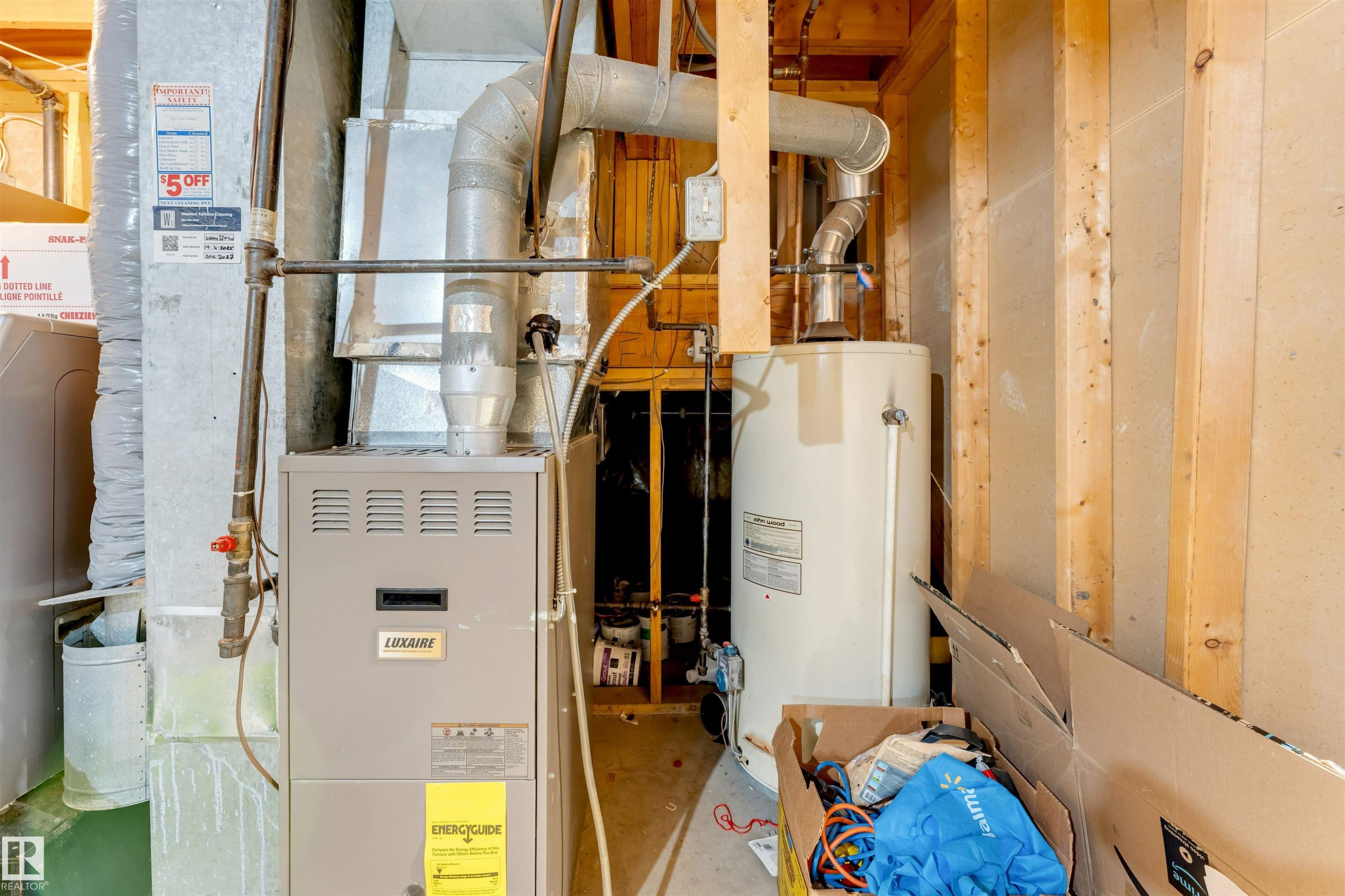 Utility area featuring a furnace and a water heater, with exposed timber framing and concrete block walls - 3332 43 Street Nw, Edmonton, AB