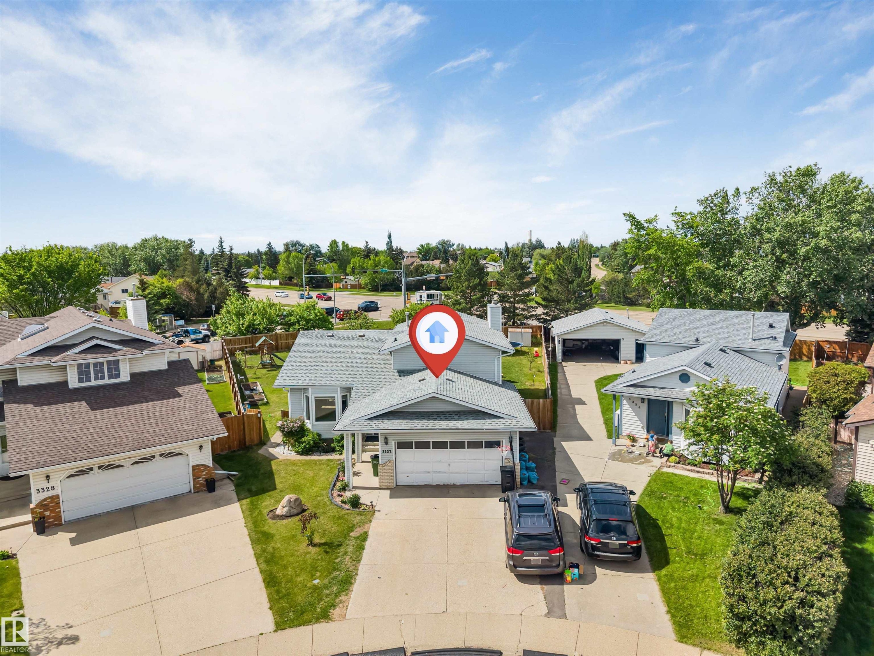 Split-level residence featuring a gray shingle roof, attached garage, and paved driveway - 3332 43 Street Nw, Edmonton, AB