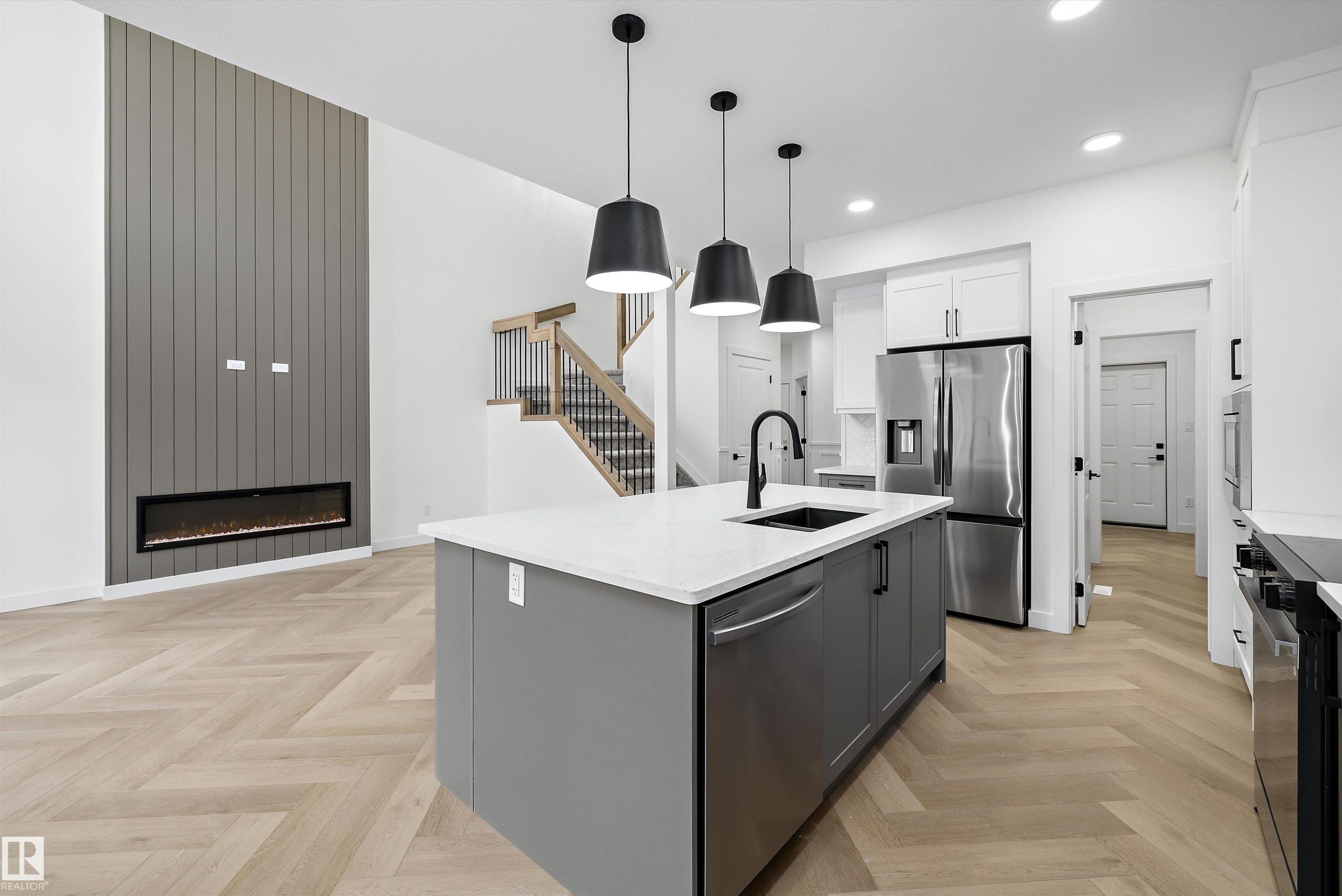 Open-concept living space with herringbone wood-finish flooring - 917 Elderberry Landing, Edmonton, AB