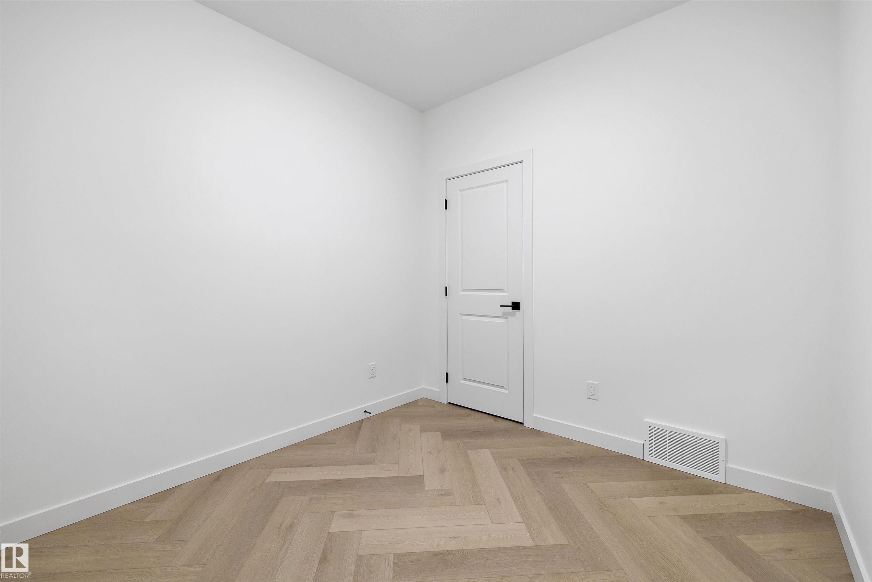 Herringbone pattern wood-finish flooring with crisp white baseboards and walls - 917 Elderberry Landing, Edmonton, AB