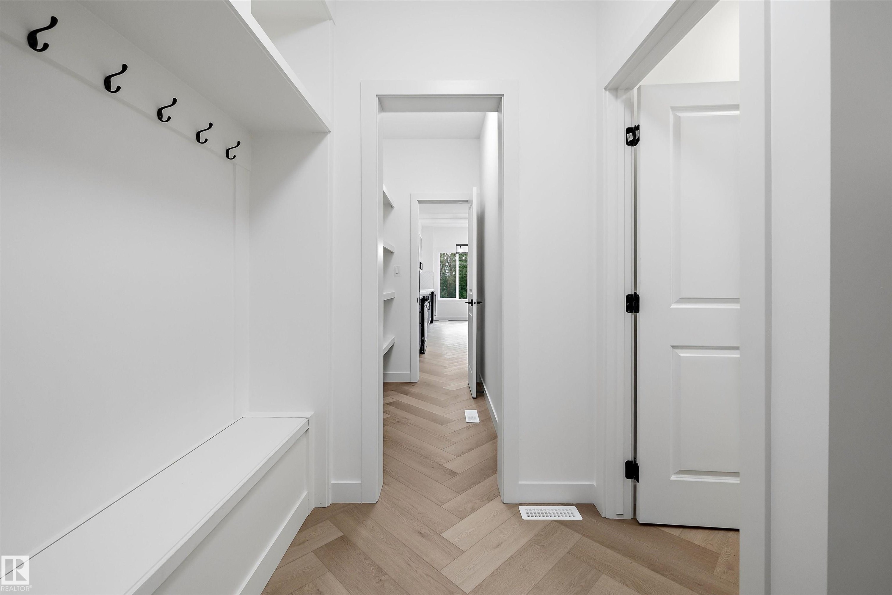 Entryway with custom built-in bench and storage shelf featuring matte black hooks - 917 Elderberry Landing, Edmonton, AB