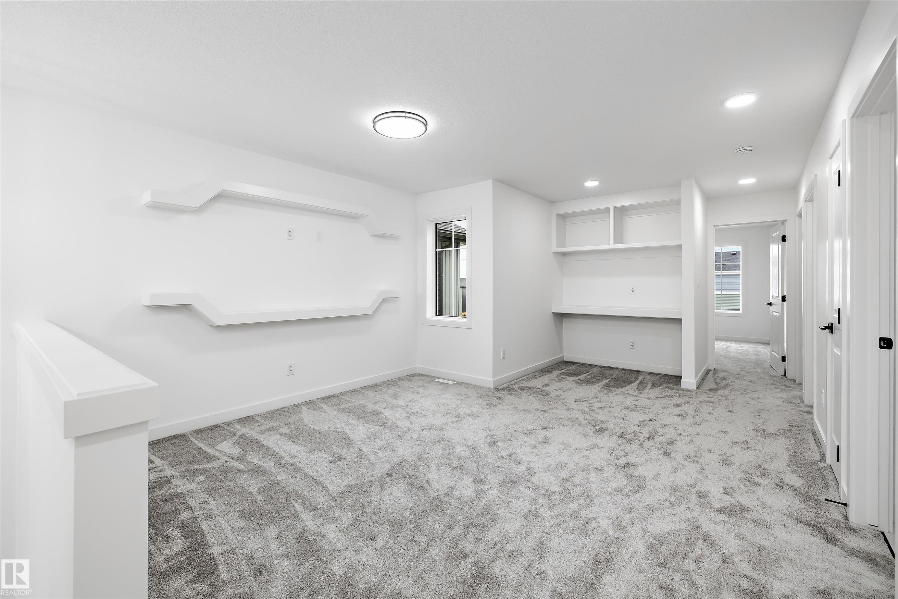 Carpeted room with a built-in desk and shelving - 917 Elderberry Landing, Edmonton, AB