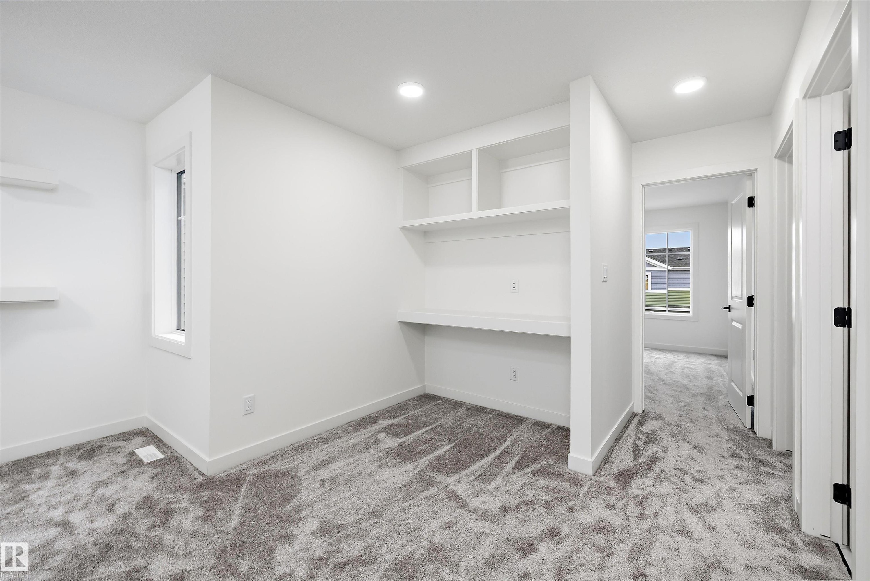 Room featuring built-in shelving and desk space, recessed lighting, and a neutral carpet - 917 Elderberry Landing, Edmonton, AB