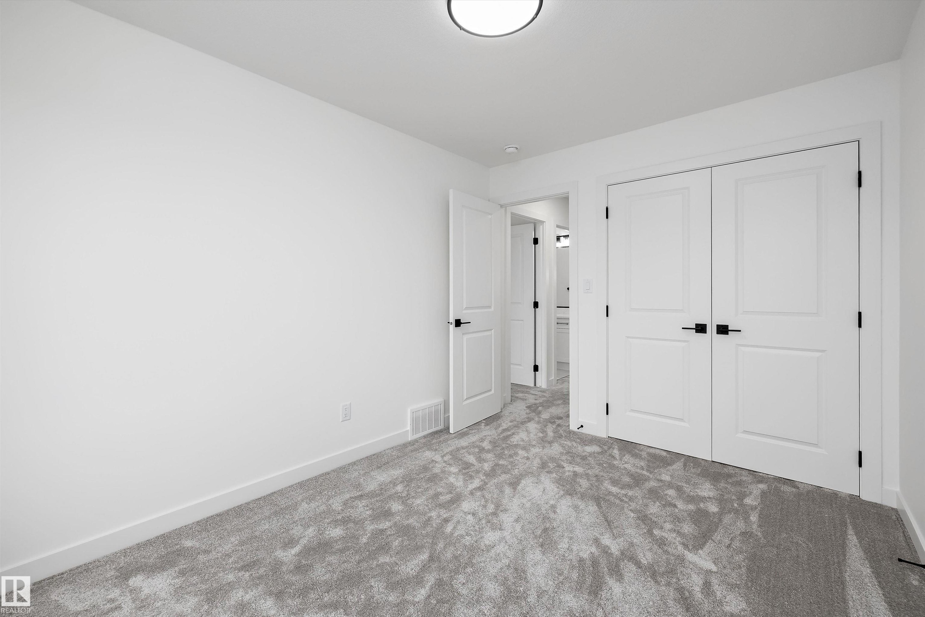 Room featuring light gray patterned carpeting, white painted walls, and white trim - 917 Elderberry Landing, Edmonton, AB