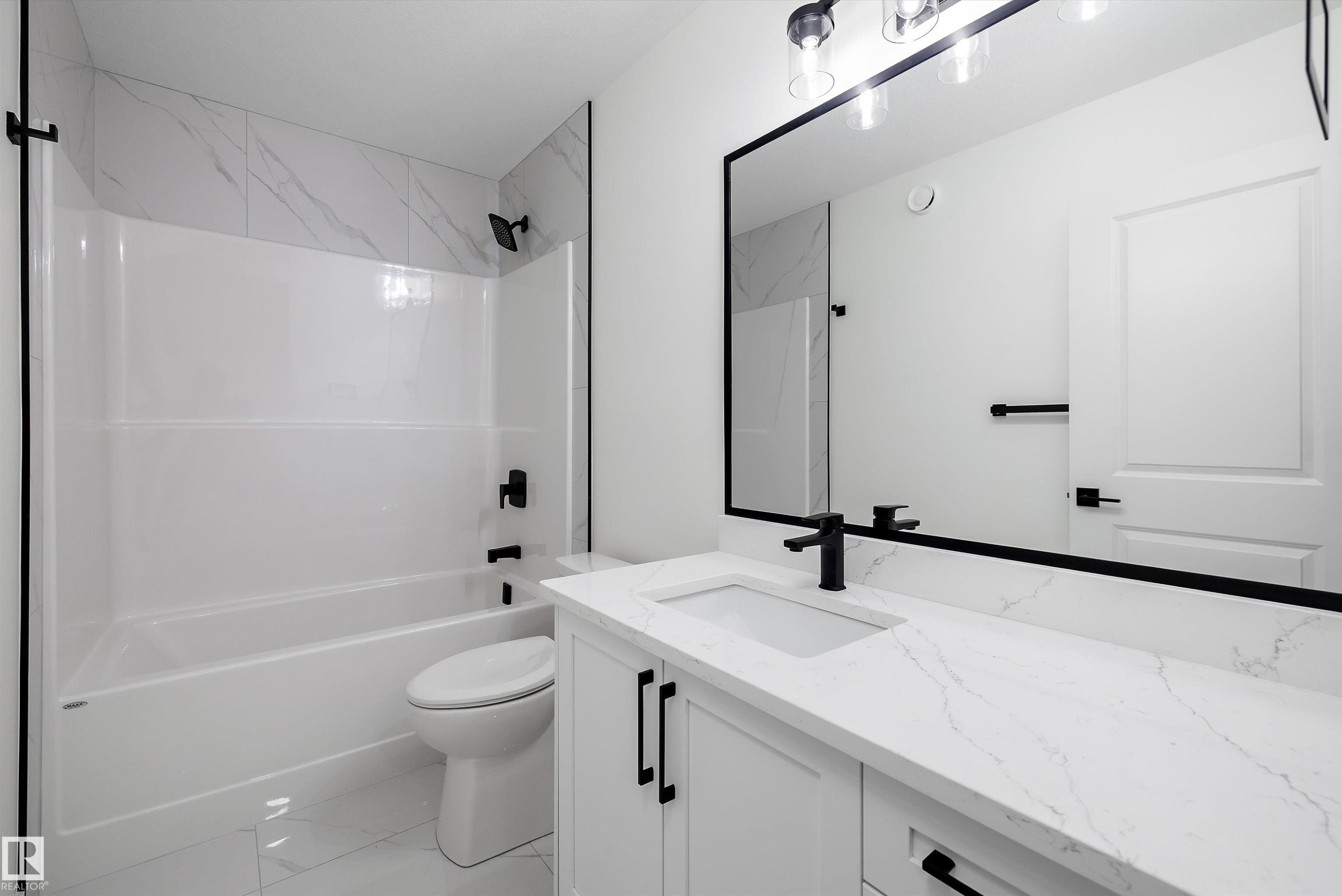 White vanity with a rectangular undermount sink, a white countertop, and matte black hardware - 917 Elderberry Landing, Edmonton, AB