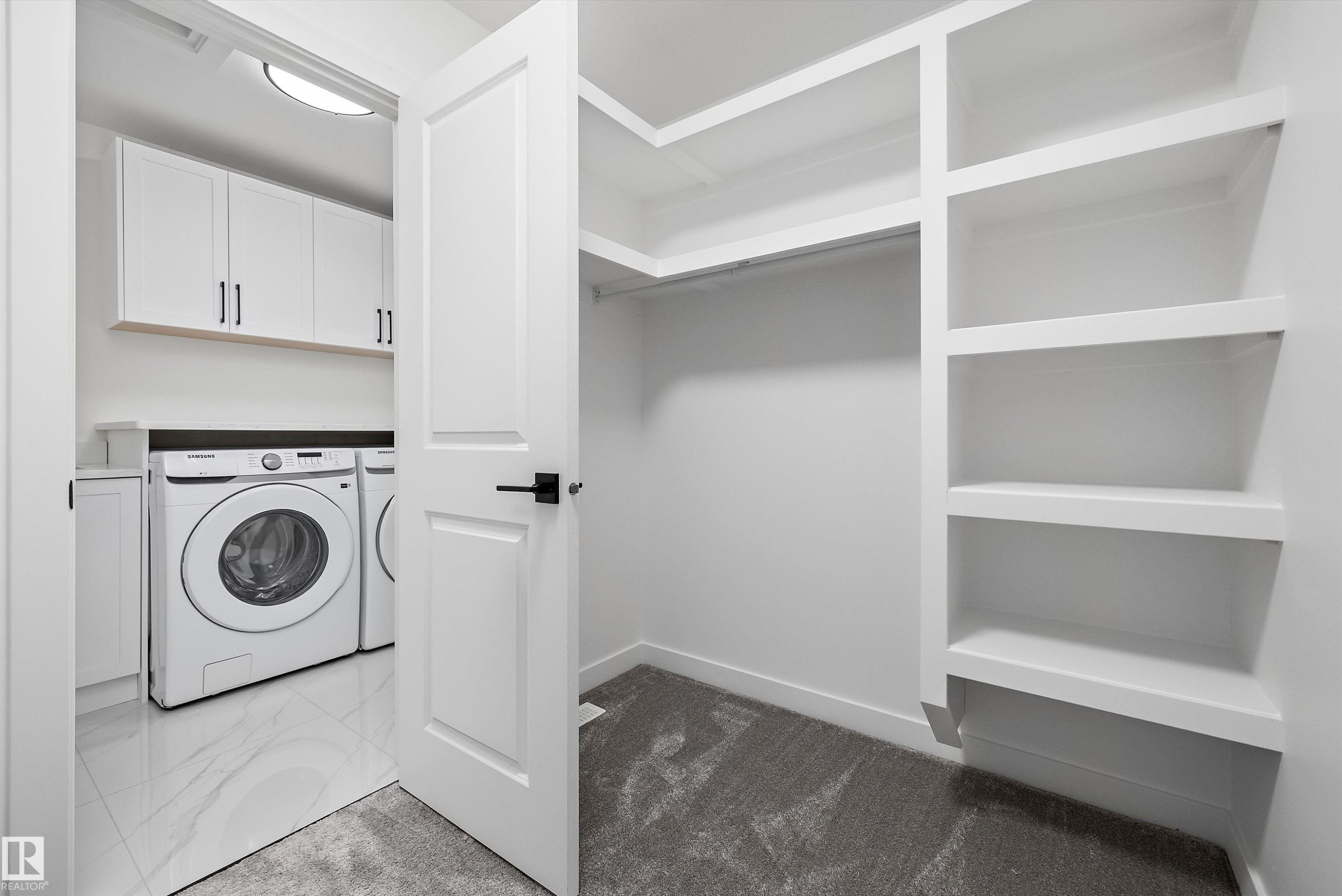 Dedicated laundry area with white cabinetry and a built-in countertop - 917 Elderberry Landing, Edmonton, AB