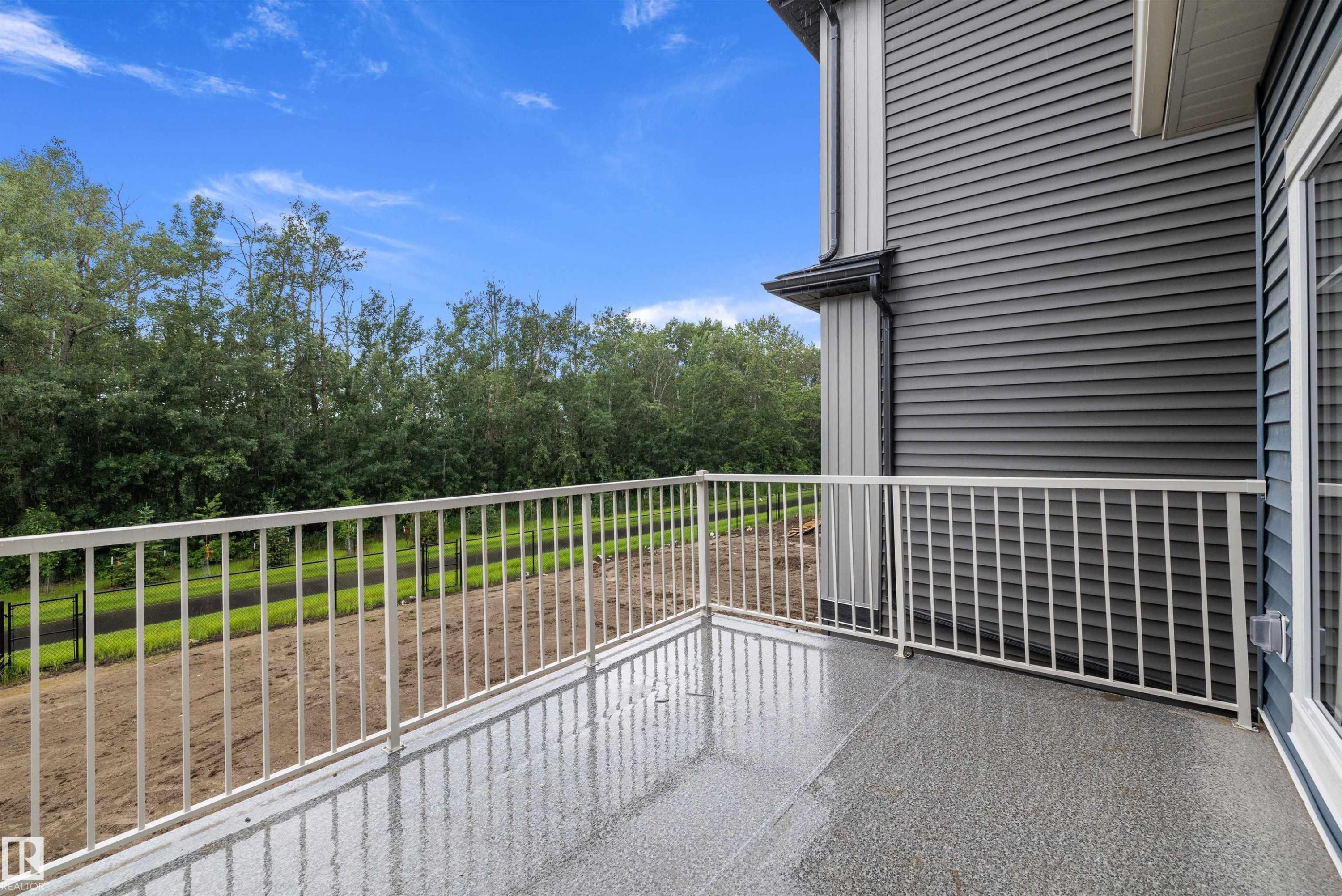 Private balcony featuring a textured gray surface and a white metal railing - 917 Elderberry Landing, Edmonton, AB