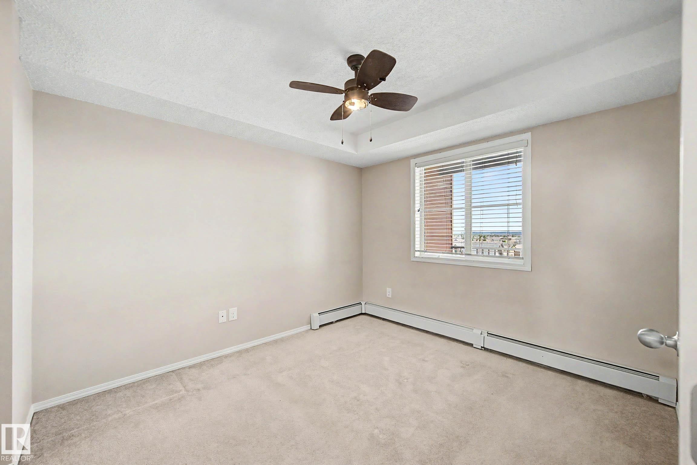 Neutral tone walls with an integrated ceiling fan and light fixture - 404 1080 Mcconachie Boulevard, Edmonton, AB