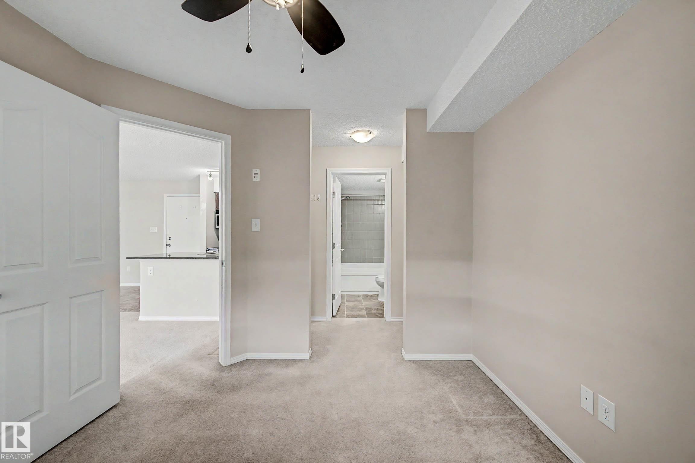 Carpeted interior space with a ceiling fan light fixture - 404 1080 Mcconachie Boulevard, Edmonton, AB