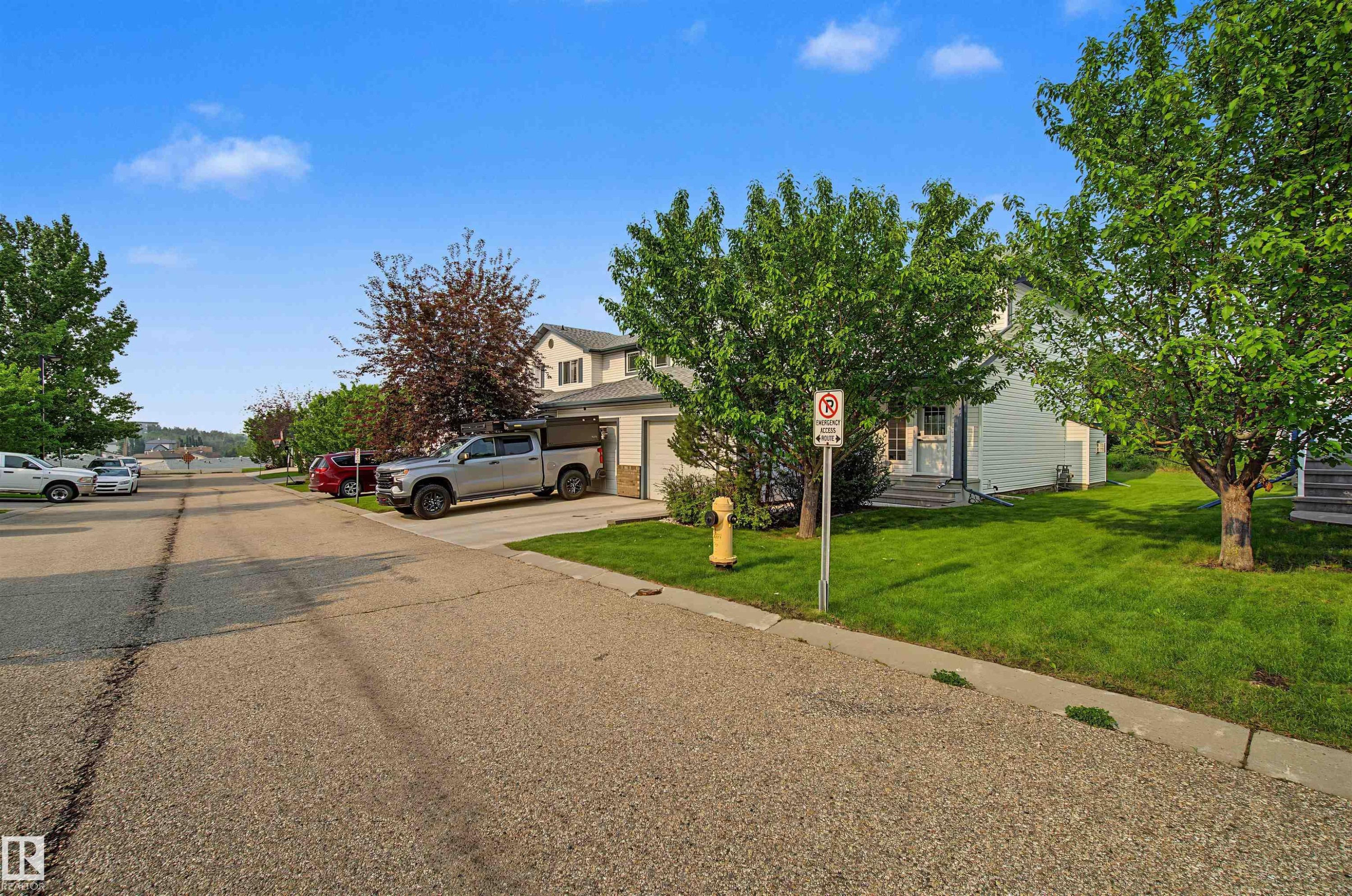 Two-story residence featuring a white siding exterior and an attached single-car garage - 15 450 Hyndman Crescent, Edmonton, AB
