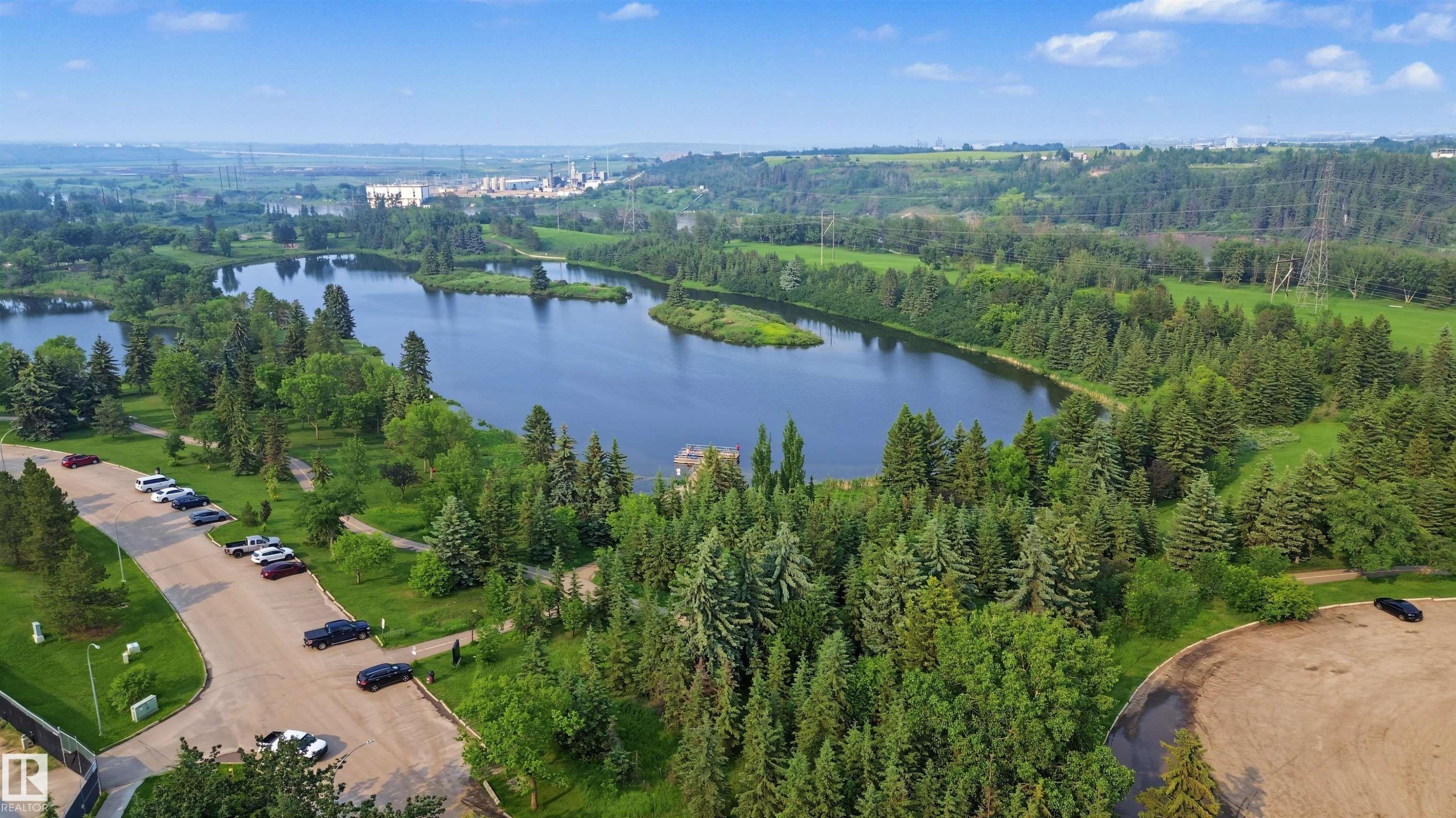 Expansive lake with a central island surrounded by mature evergreen and deciduous trees - 15 450 Hyndman Crescent, Edmonton, AB