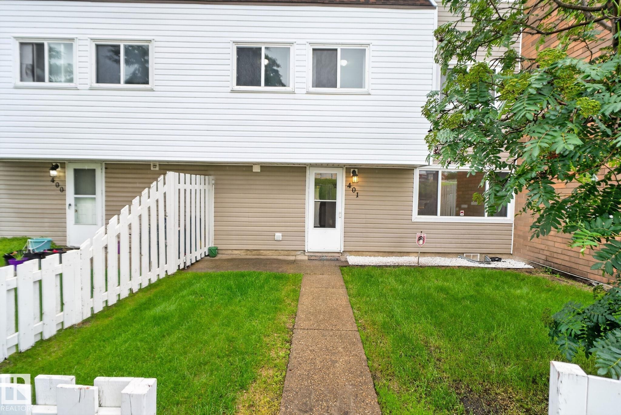 Two-story townhome featuring white horizontal siding and a complementary tan lower facade - 401 2908 116A Avenue, Edmonton, AB