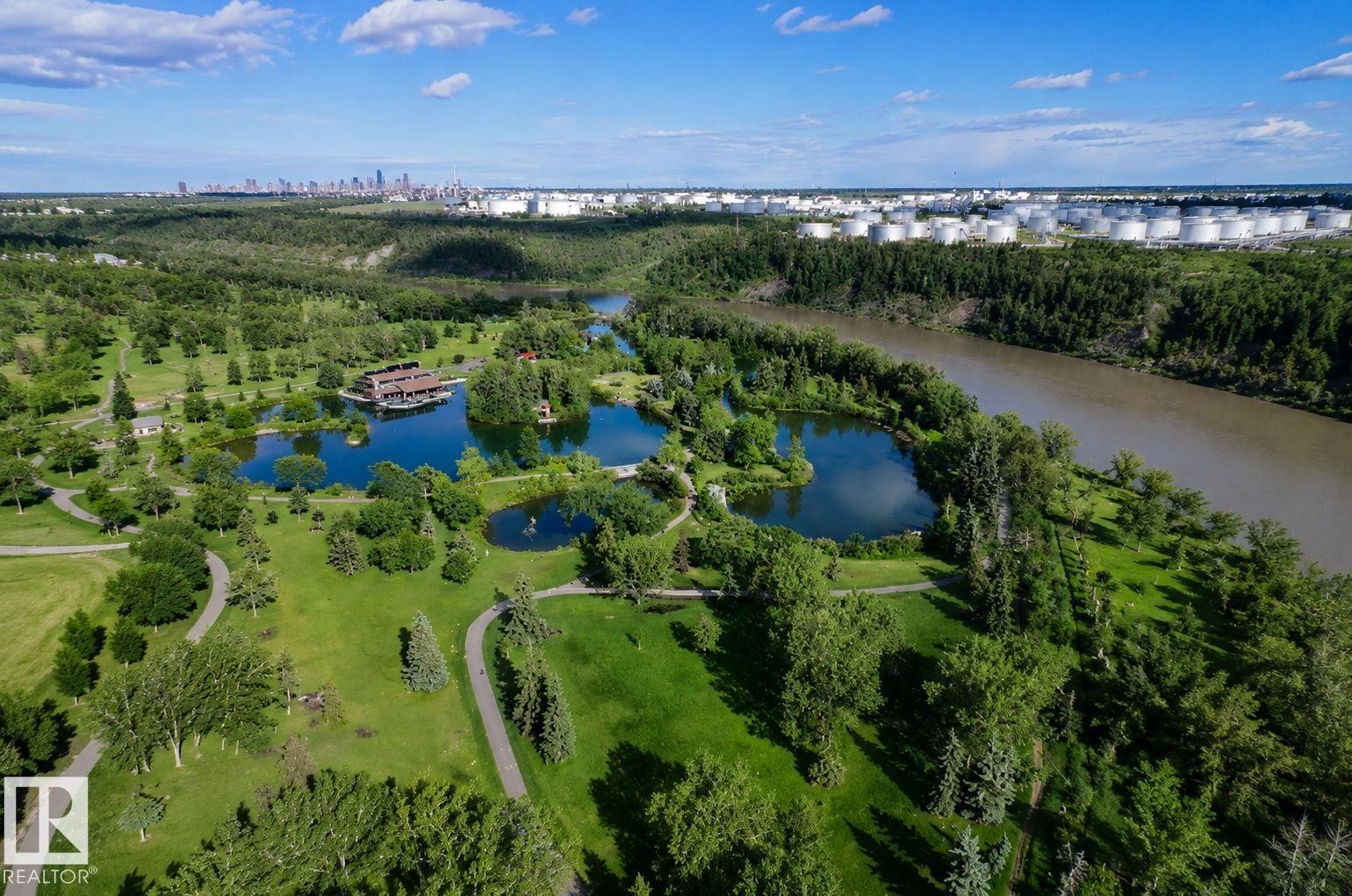 Expansive parkland featuring multiple ponds, mature trees, and winding paved pathways - 401 2908 116A Avenue, Edmonton, AB