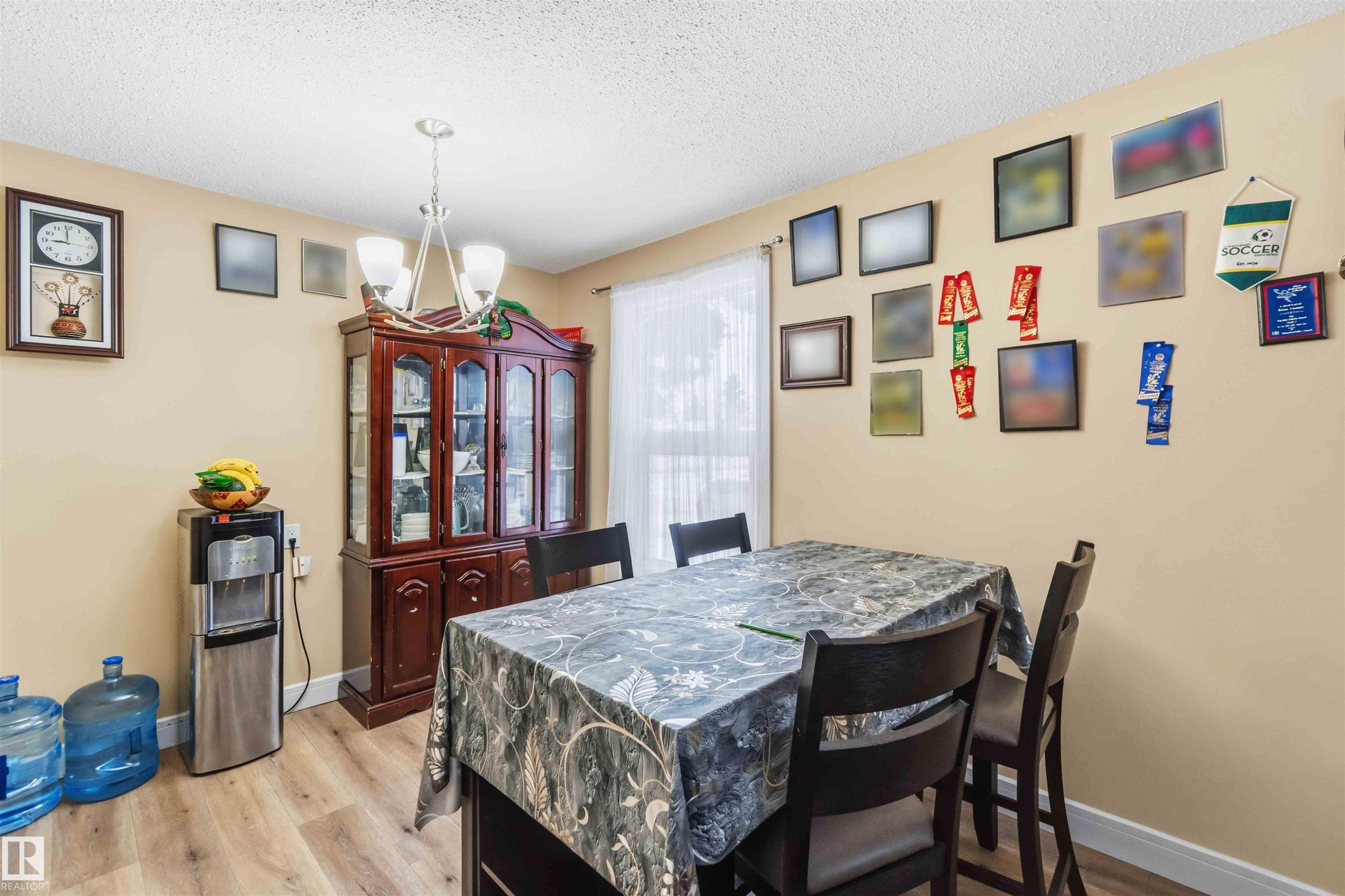 Dining area featuring wood-finish flooring and a central chandelier - 17118 108 Street, Edmonton, AB