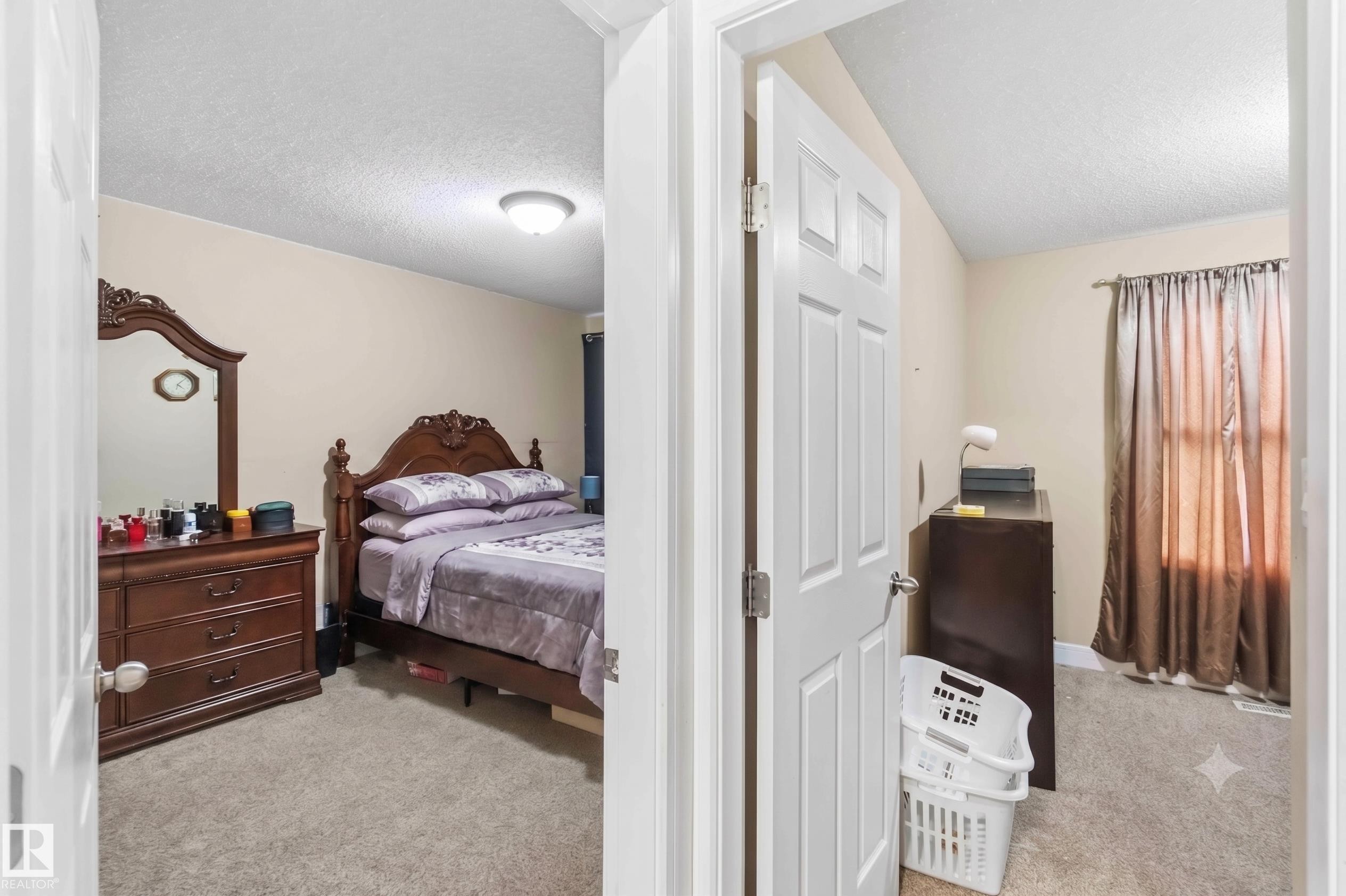 Carpeted bedroom featuring neutral wall tones and a ceiling-mounted light fixture - 17118 108 Street, Edmonton, AB