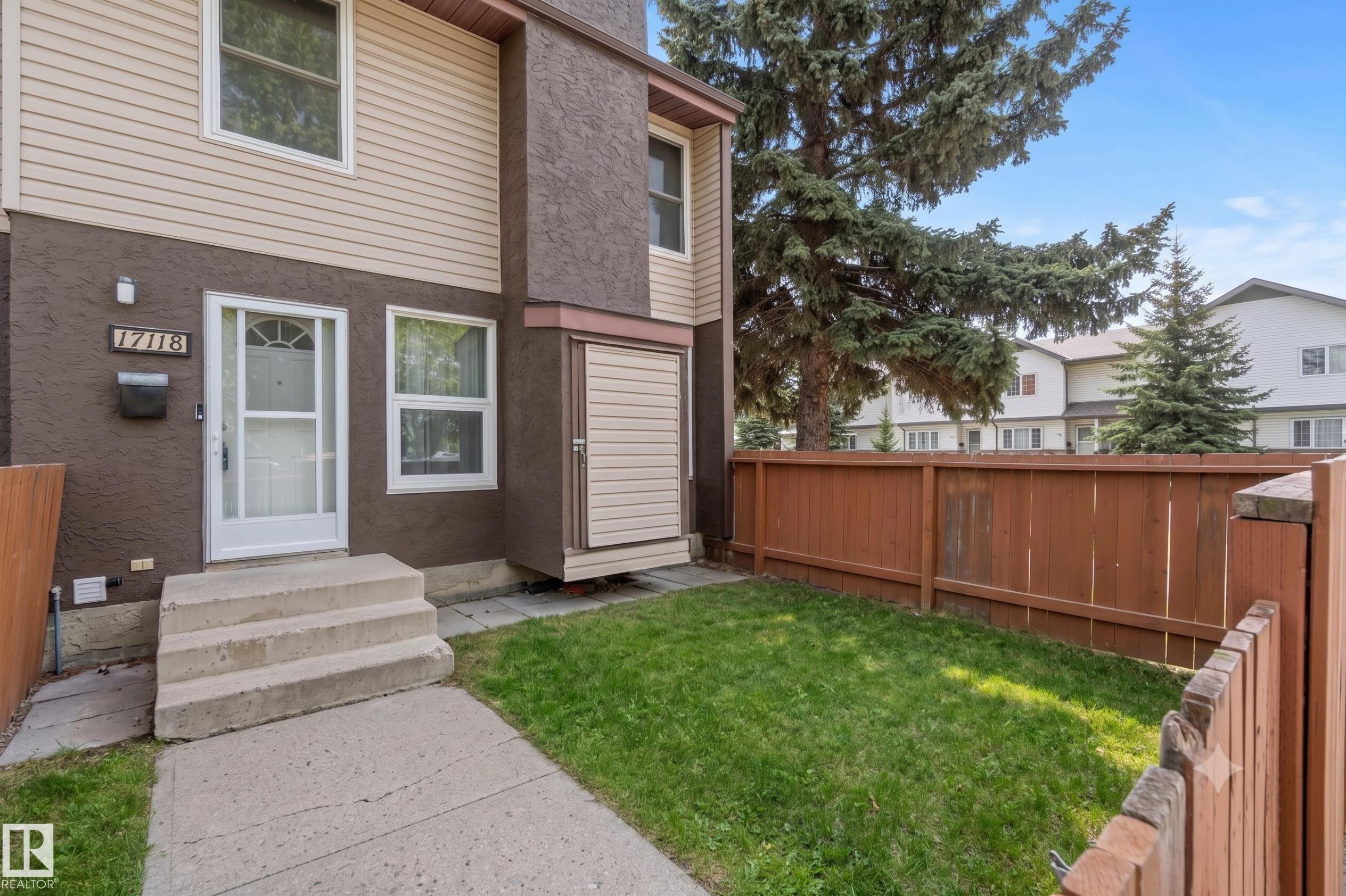 Two-story residence featuring a brown stucco and beige siding exterior - 17118 108 Street, Edmonton, AB