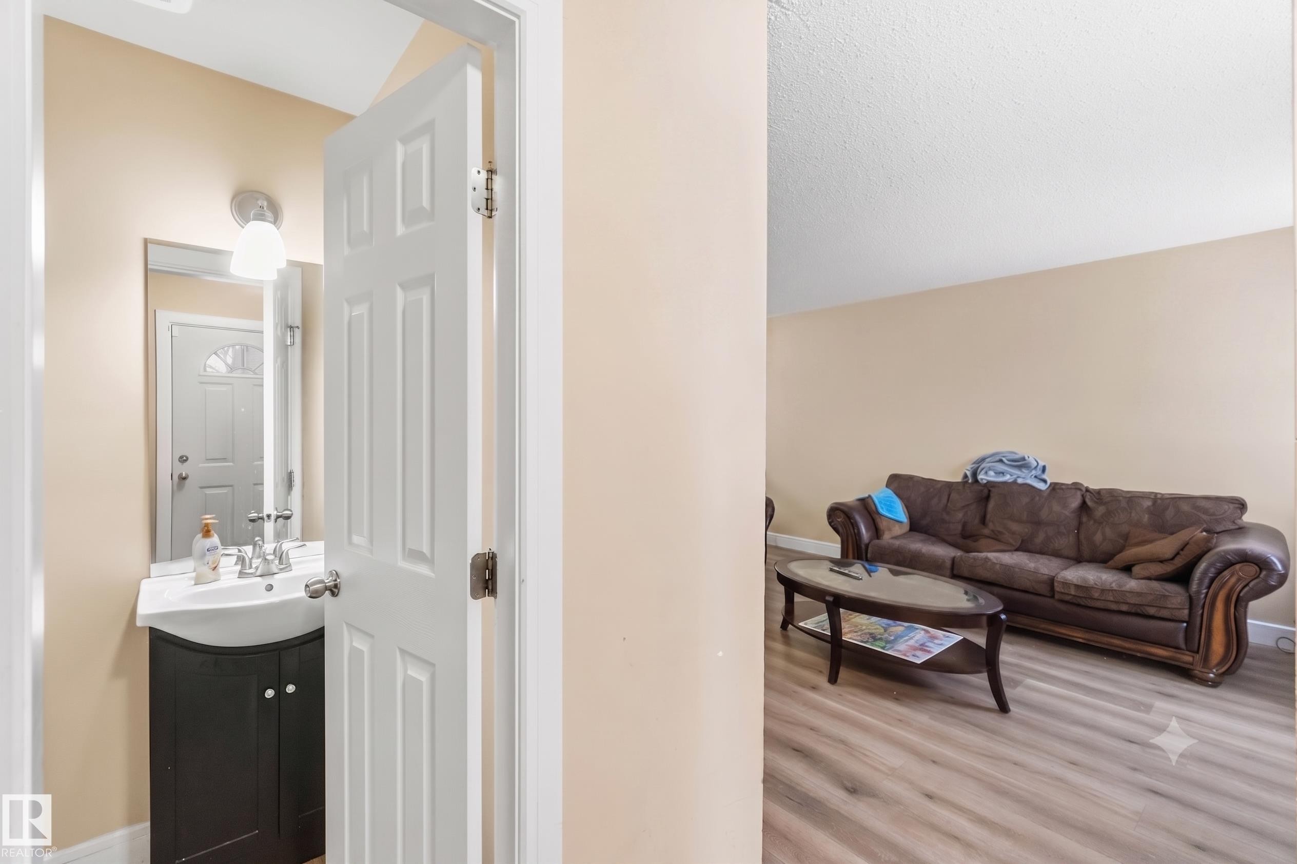 Bathroom vanity with a white ceramic sink, chrome faucet, and dark wood-finish cabinetry - 17118 108 Street, Edmonton, AB