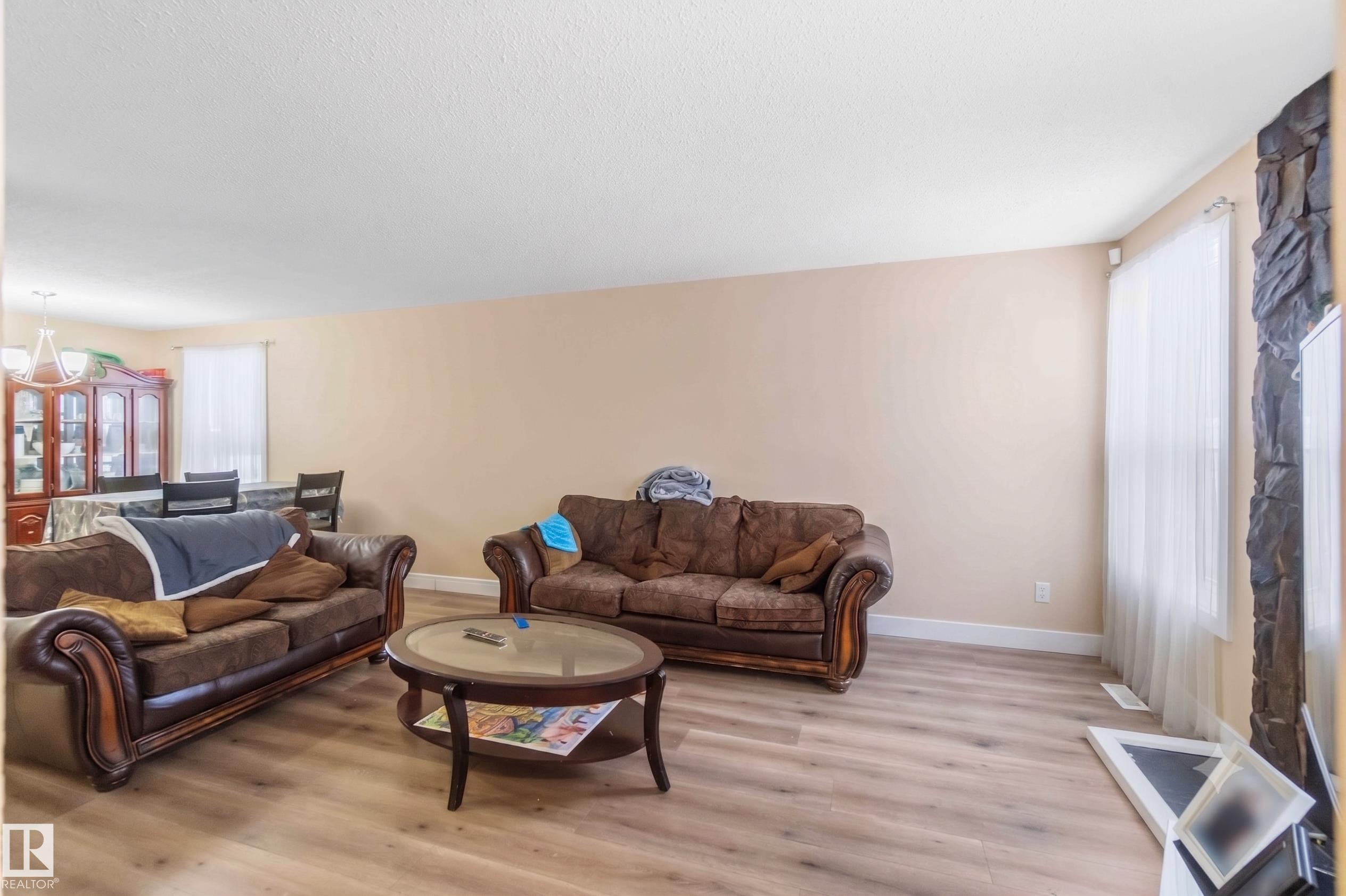 Spacious living area featuring wood-finish flooring and neutral wall tones - 17118 108 Street, Edmonton, AB