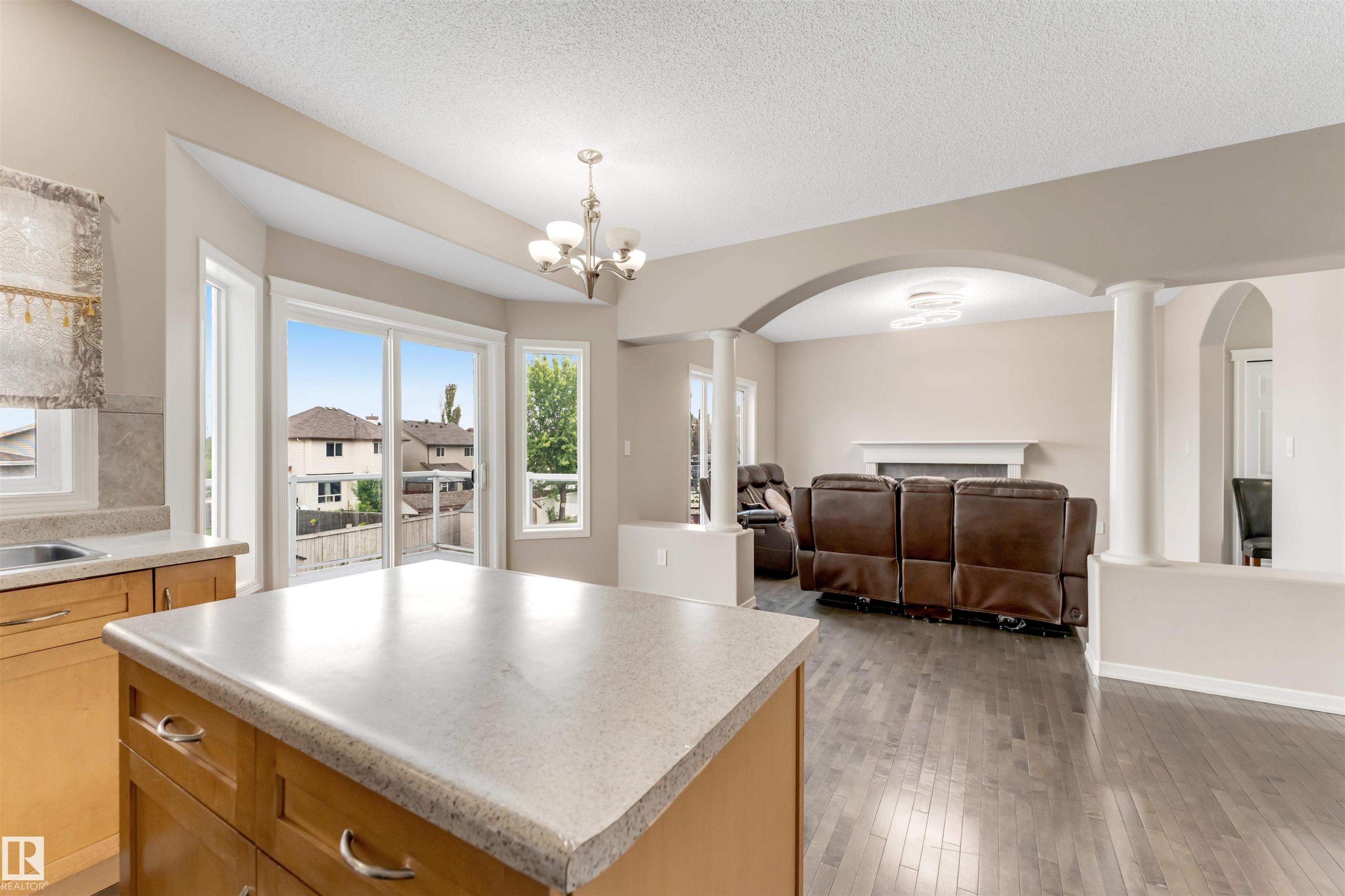 Kitchen island with light-toned countertop and wood cabinetry - 3449 28 Street, Edmonton, AB