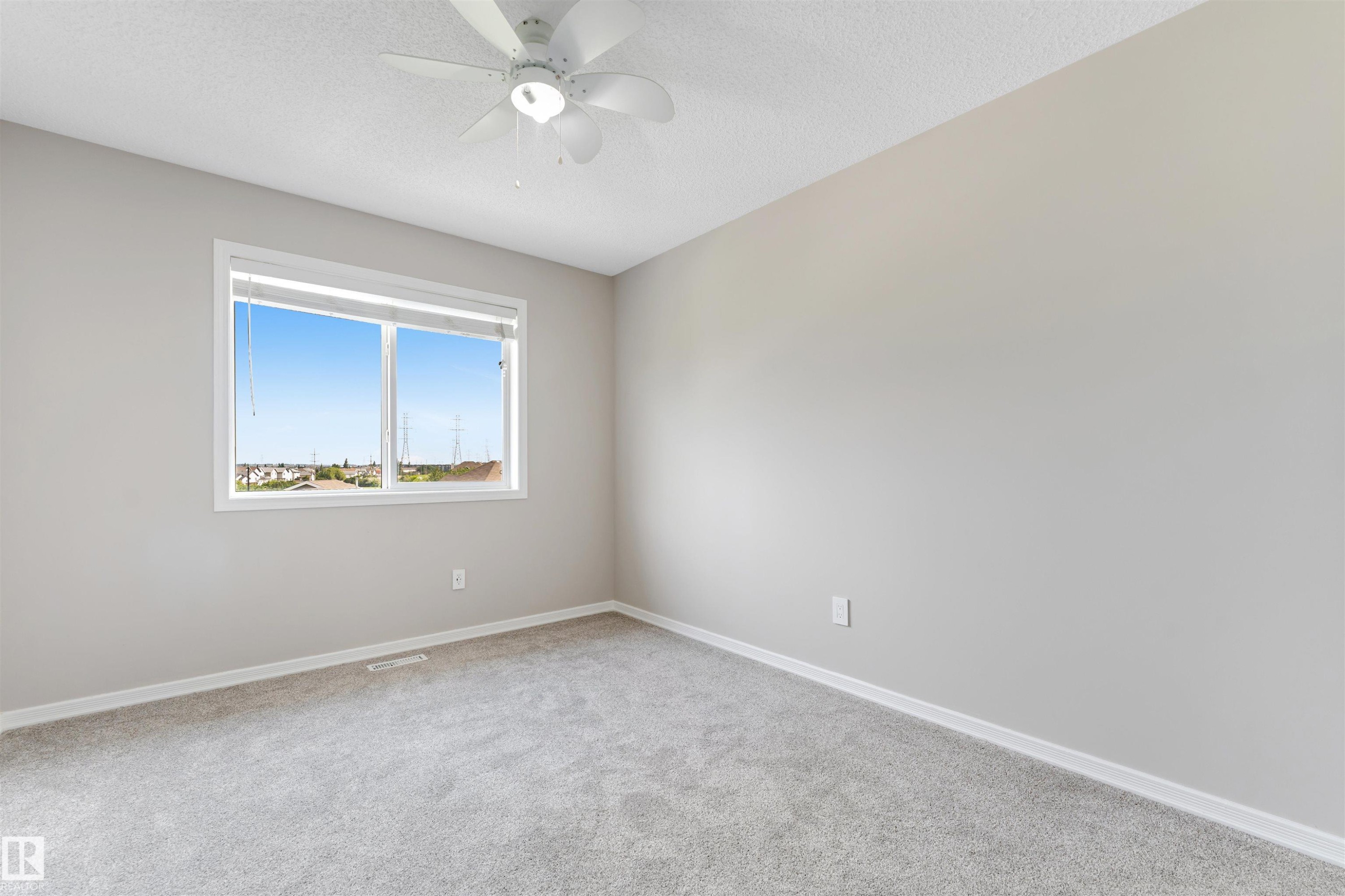 Neutral tone walls with a ceiling fan light fixture - 3449 28 Street, Edmonton, AB