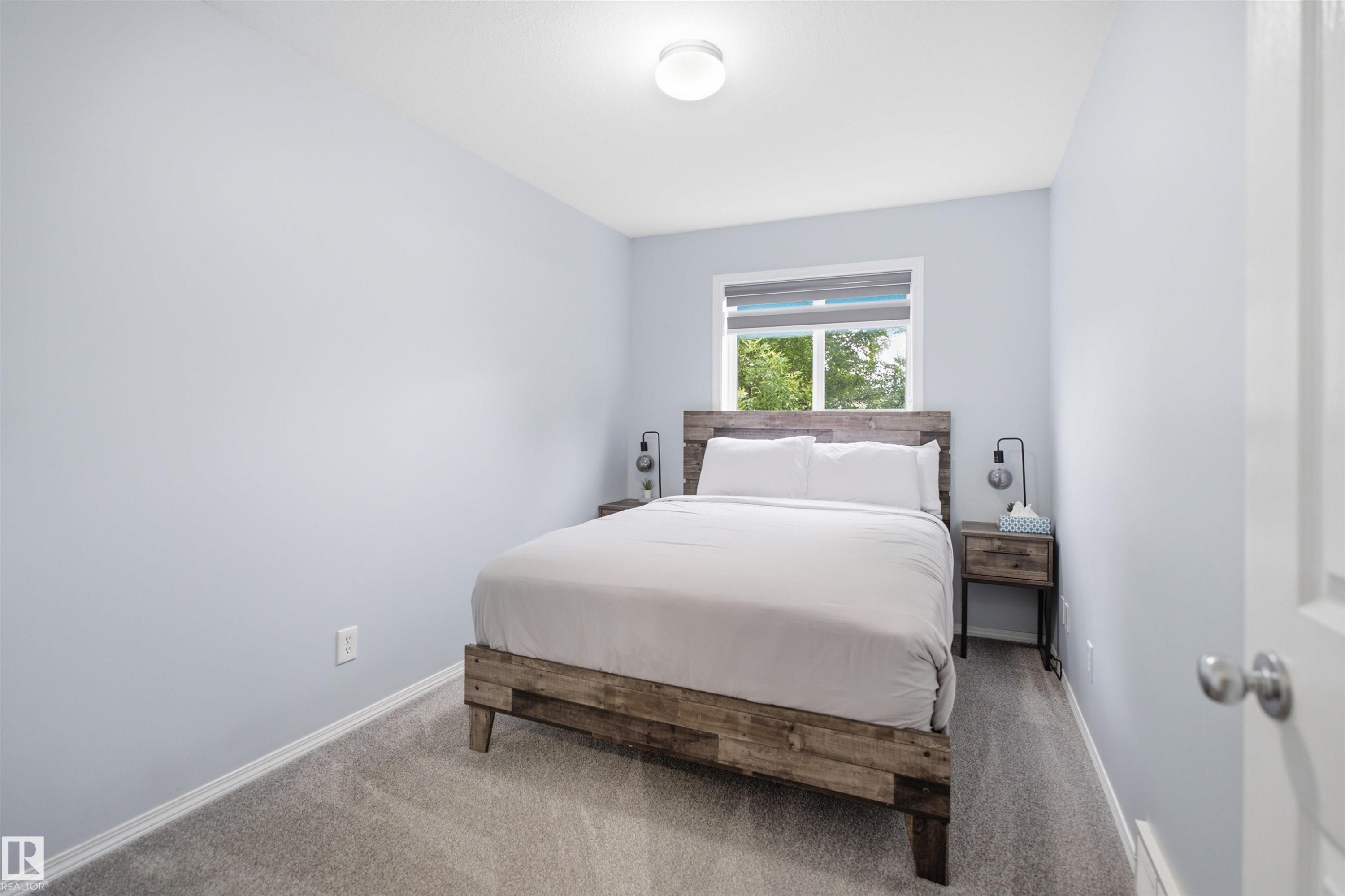 Carpeted room featuring light blue walls and a window with blinds - 92 230 Edwards Drive, Edmonton, AB