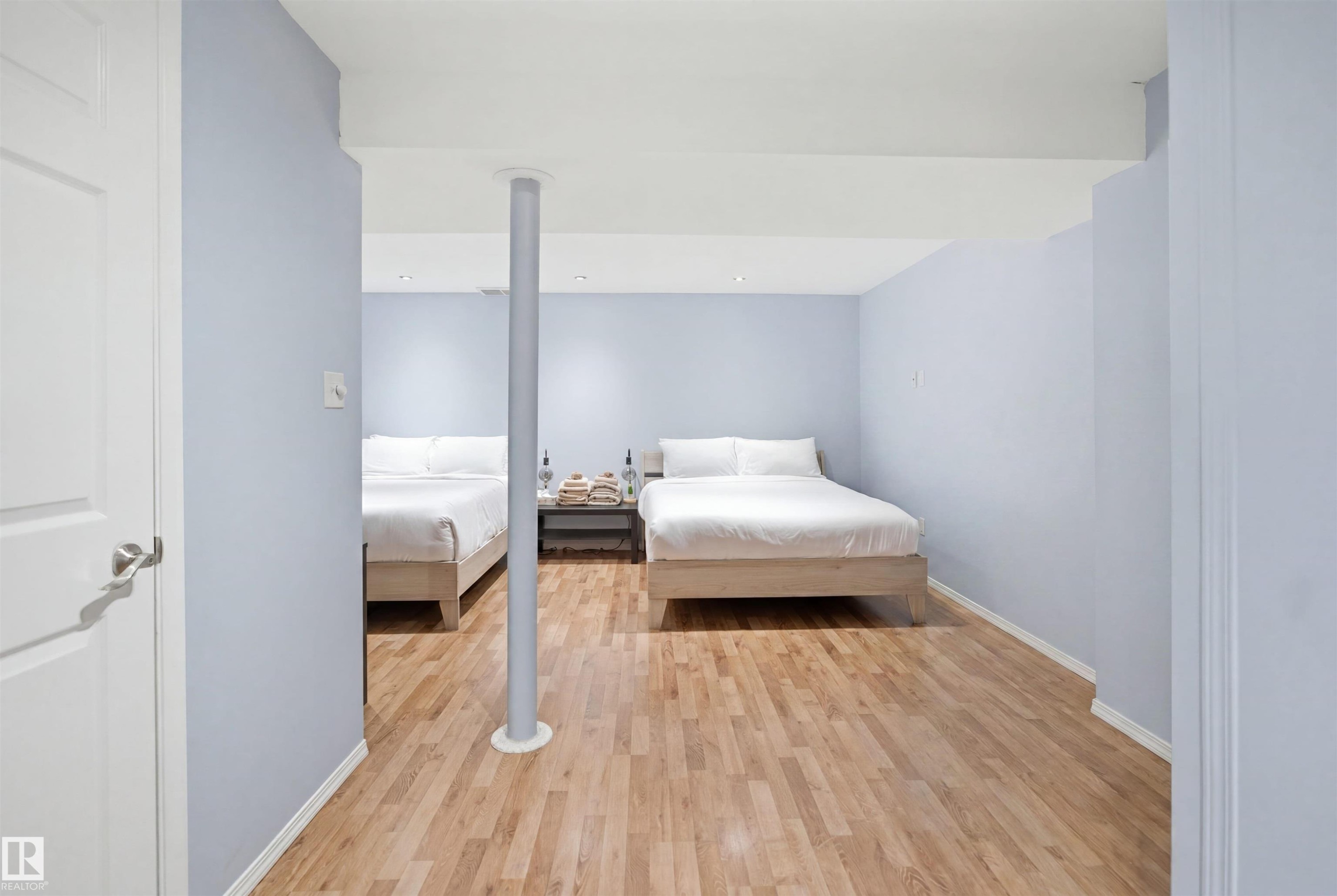 Spacious interior room featuring wood-finish flooring, light blue walls, and recessed lighting - 92 230 Edwards Drive, Edmonton, AB