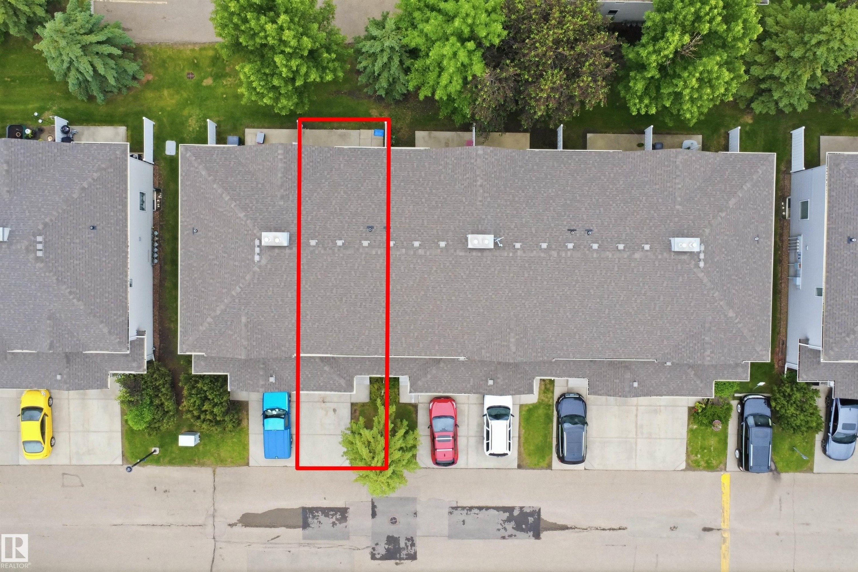 Townhome property featuring a gray shingle roof, rear patio space, and a front parking pad - 92 230 Edwards Drive, Edmonton, AB