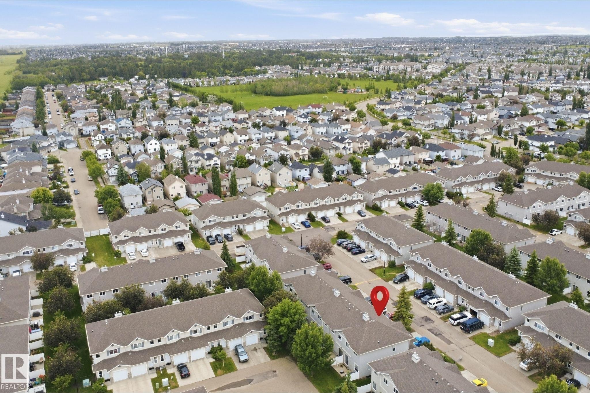 Aerial perspective showcasing a residential community with townhomes and single-family residences - 92 230 Edwards Drive, Edmonton, AB