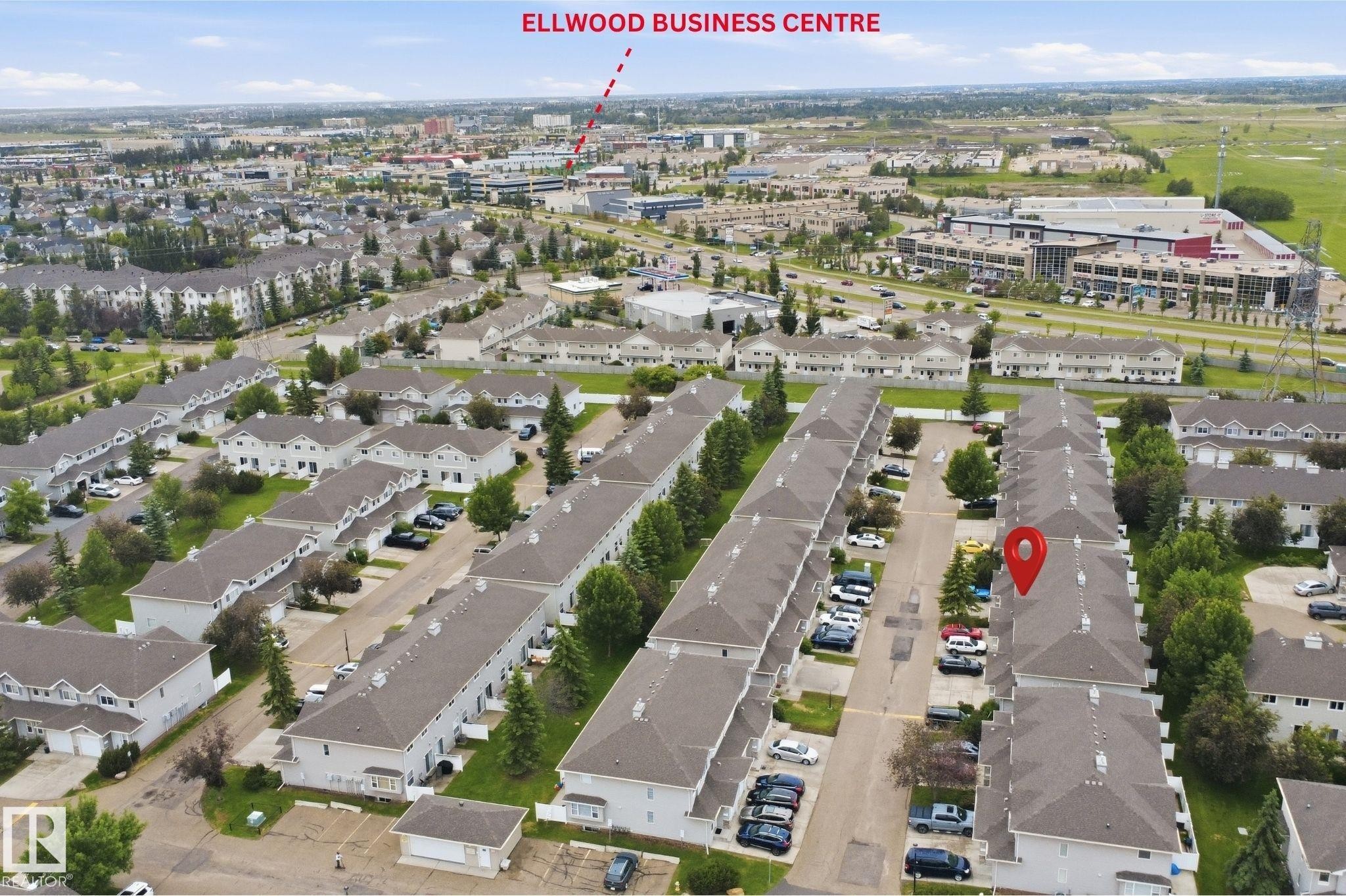 Aerial perspective of a multi-unit residential development with light-colored siding and dark-pitched roofs - 92 230 Edwards Drive, Edmonton, AB