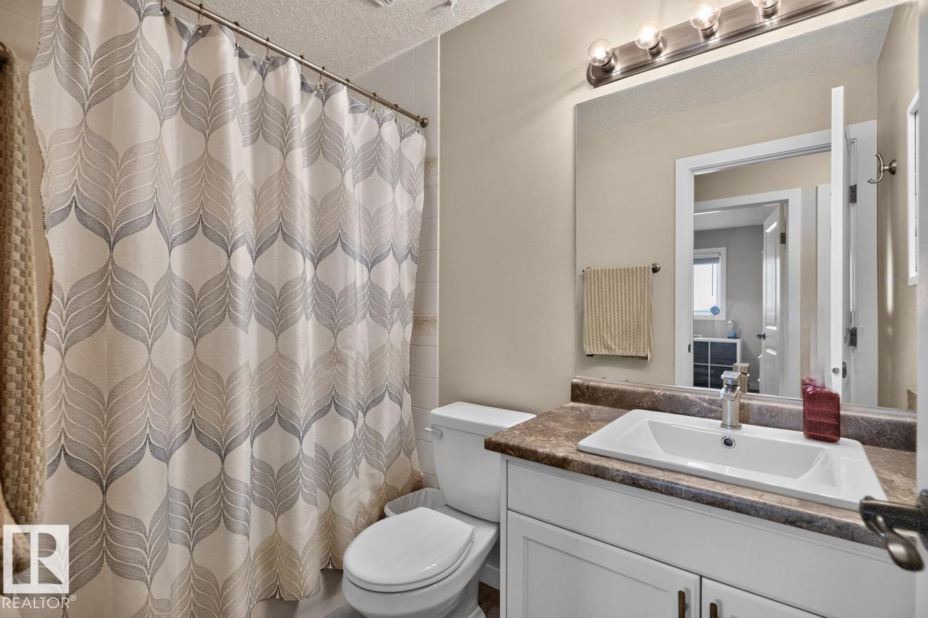 Bathroom featuring a white vanity with an integrated sink, a dark countertop, and a chrome faucet - 448 Ormsby Road Nw, Edmonton, AB - Indoor Photo Showing Bathroom