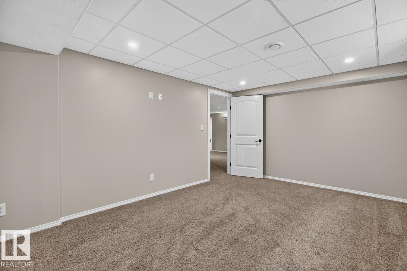 Carpeted room featuring neutral wall paint, white trim, and a drop ceiling with recessed lighting - 448 Ormsby Road Nw, Edmonton, AB - Indoor Photo Showing Other Room