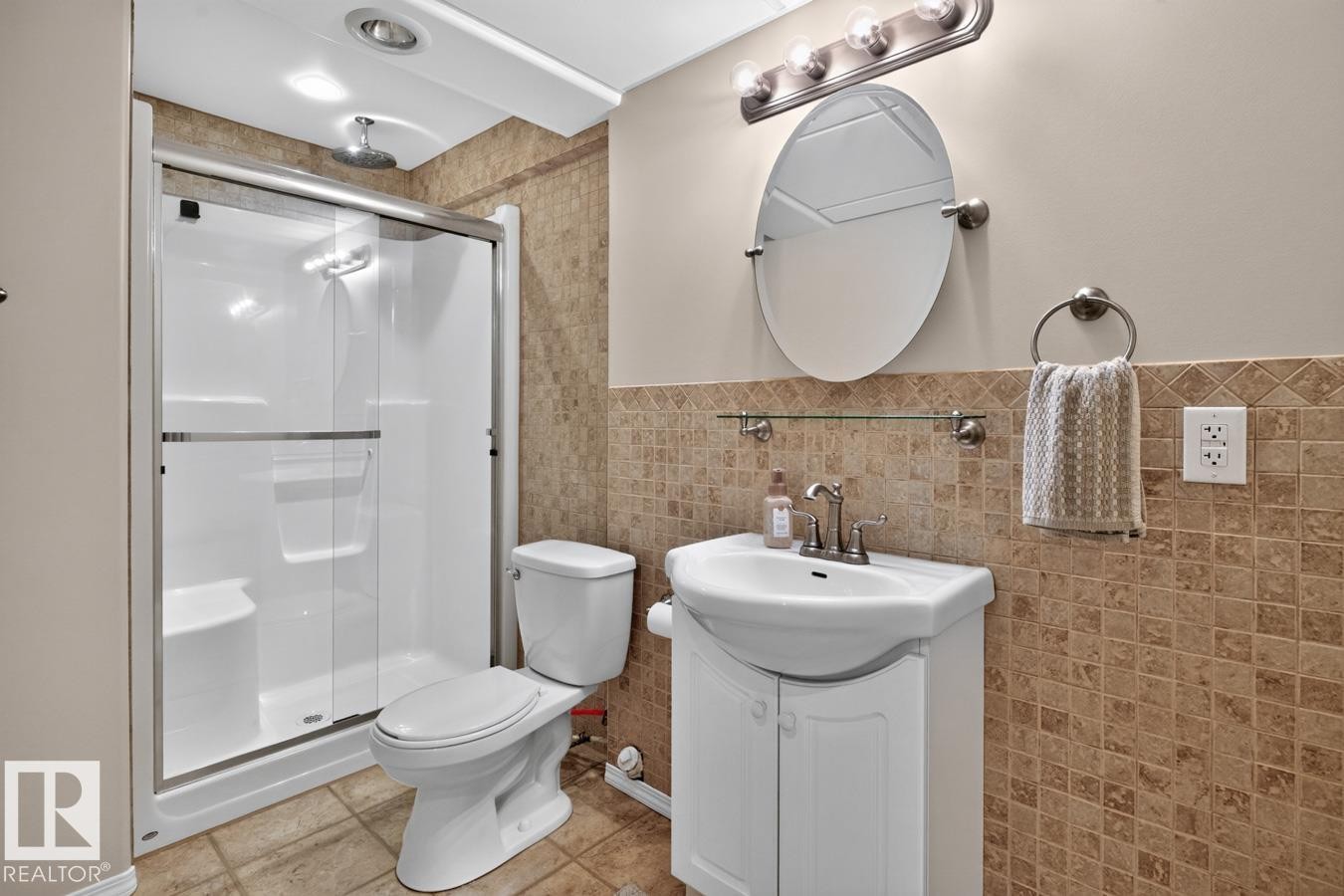 Bathroom featuring a stand-up shower with sliding glass doors, a white toilet, and a vanity with a white basin sink - 448 Ormsby Road Nw, Edmonton, AB - Indoor Photo Showing Bathroom