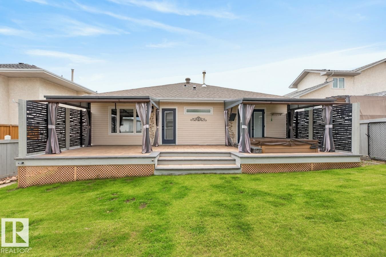 Rear exterior featuring a large elevated deck with steps to a grass lawn - 448 Ormsby Road Nw, Edmonton, AB - Outdoor With Deck Patio Veranda