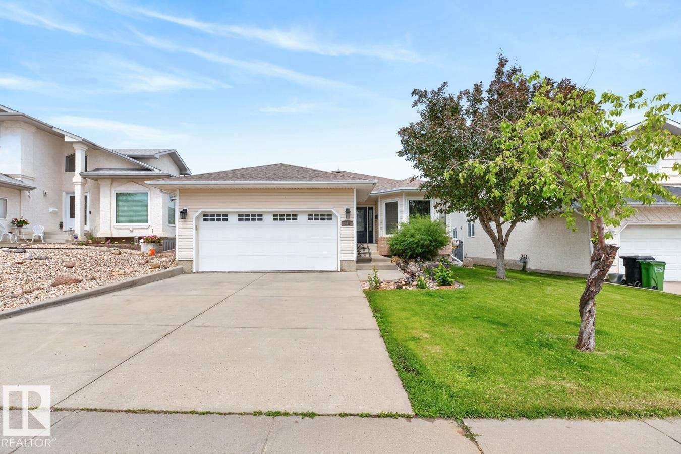 Single-story residence featuring light-colored siding, a two-car garage with window accents, and a concrete driveway - 448 Ormsby Road Nw, Edmonton, AB - Outdoor With Facade