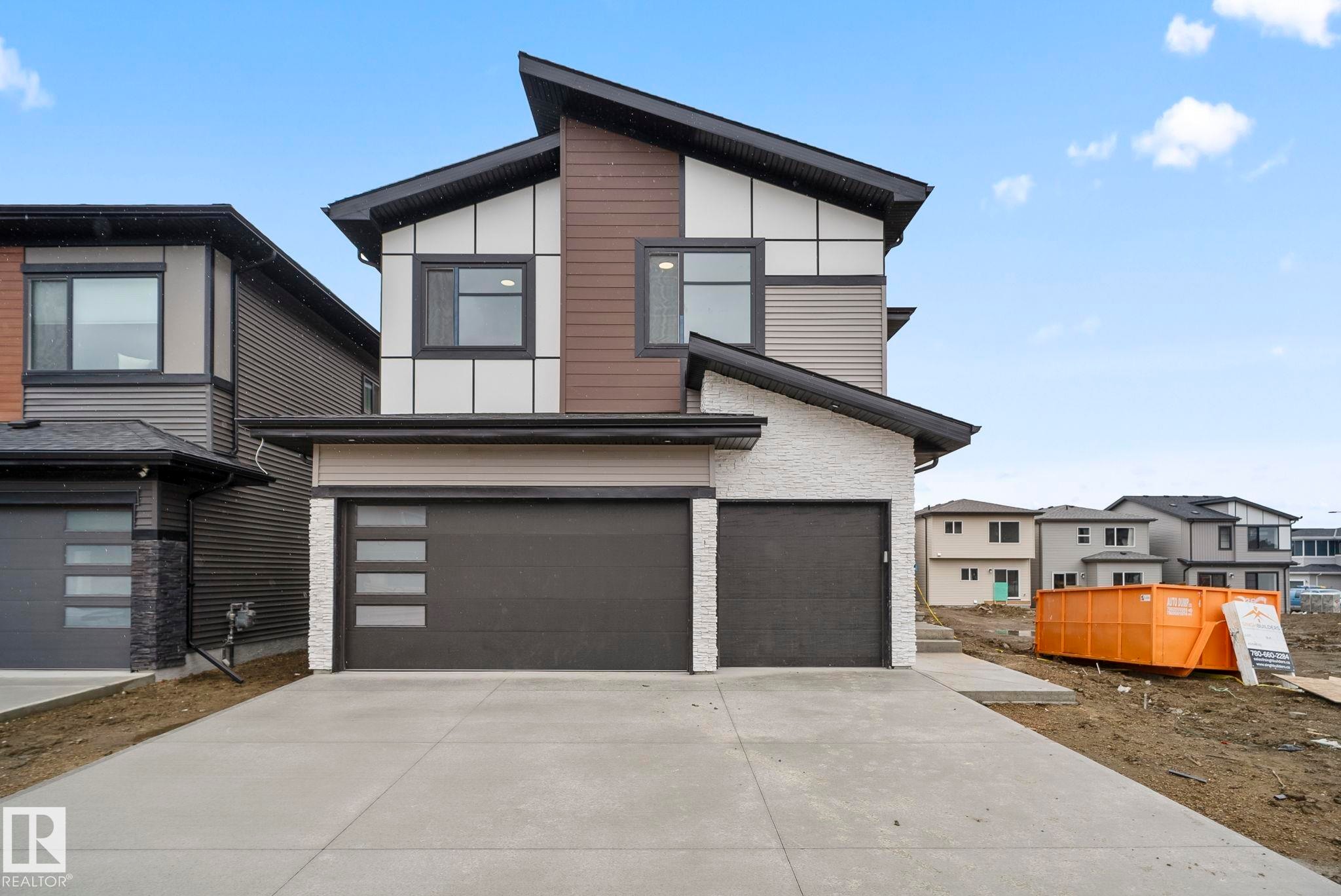 Modern architectural exterior featuring multiple material finishes, an asymmetrical roofline, and integrated two-car garages - 13152 187 Avenue, Edmonton, AB
