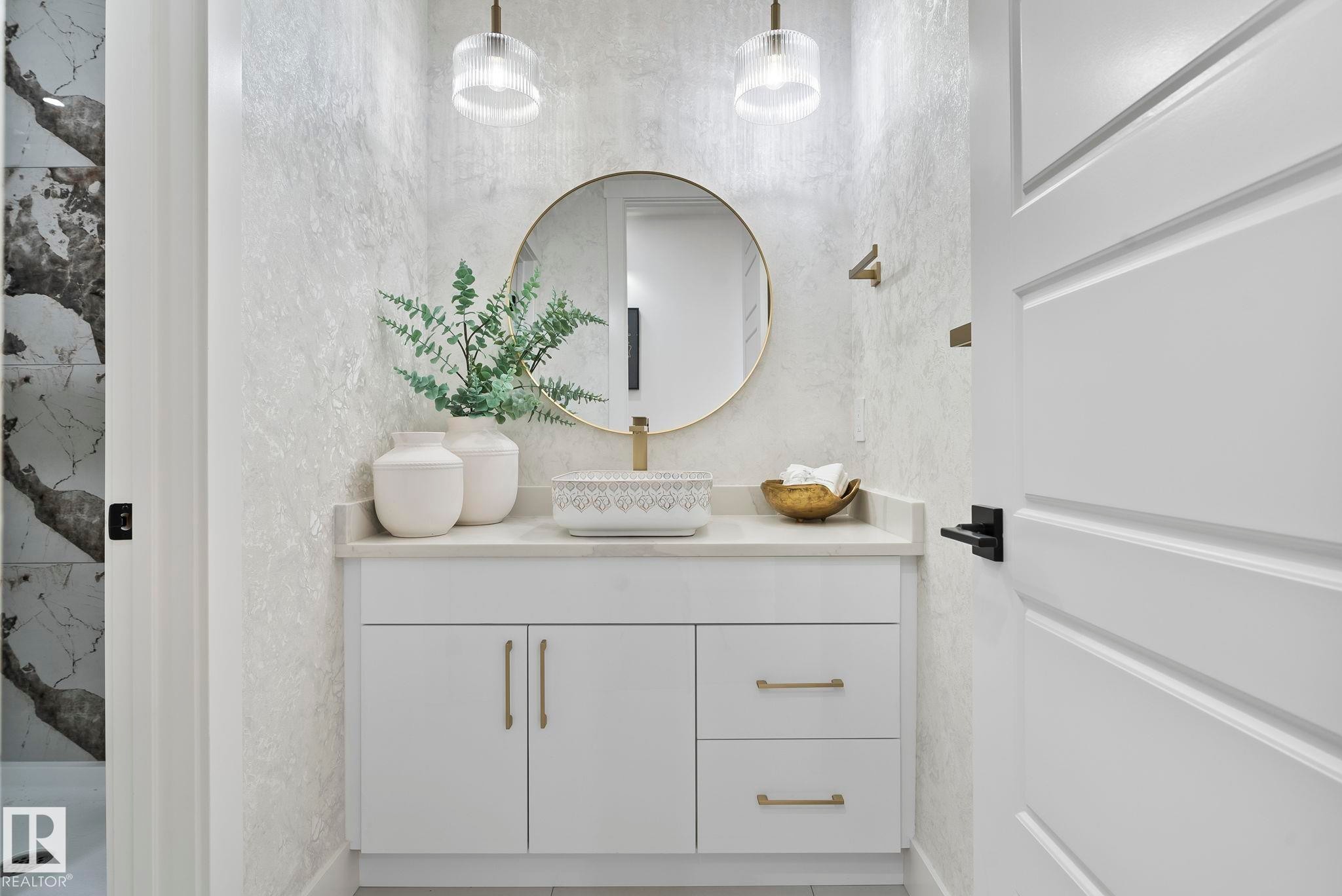 Bathroom vanity featuring a vessel sink, single-handle faucet, and round mirror with a gold-finish frame - 13152 187 Avenue, Edmonton, AB